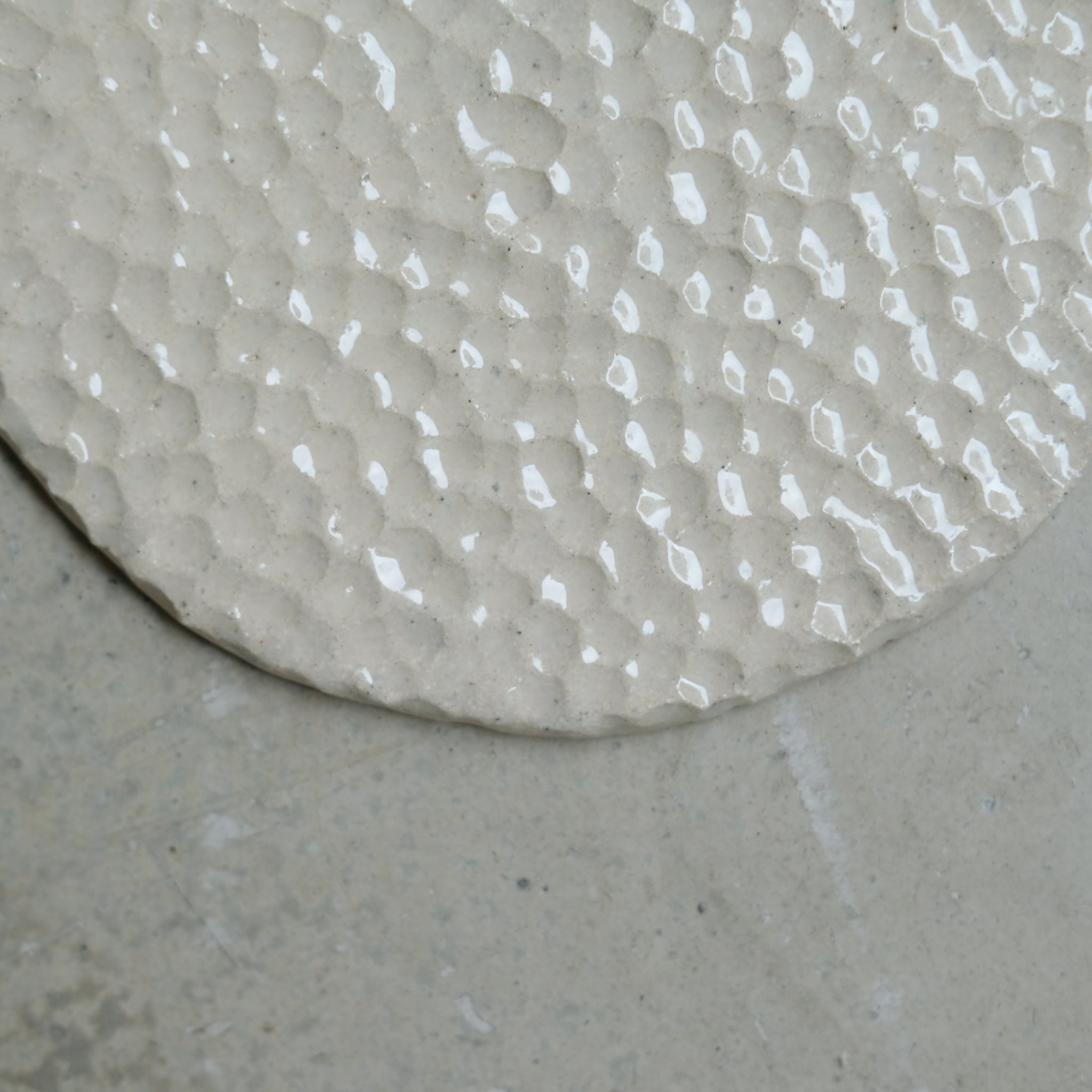 Assiette martelée en grès blanc par Simone Loo chez Brutal Ceramics