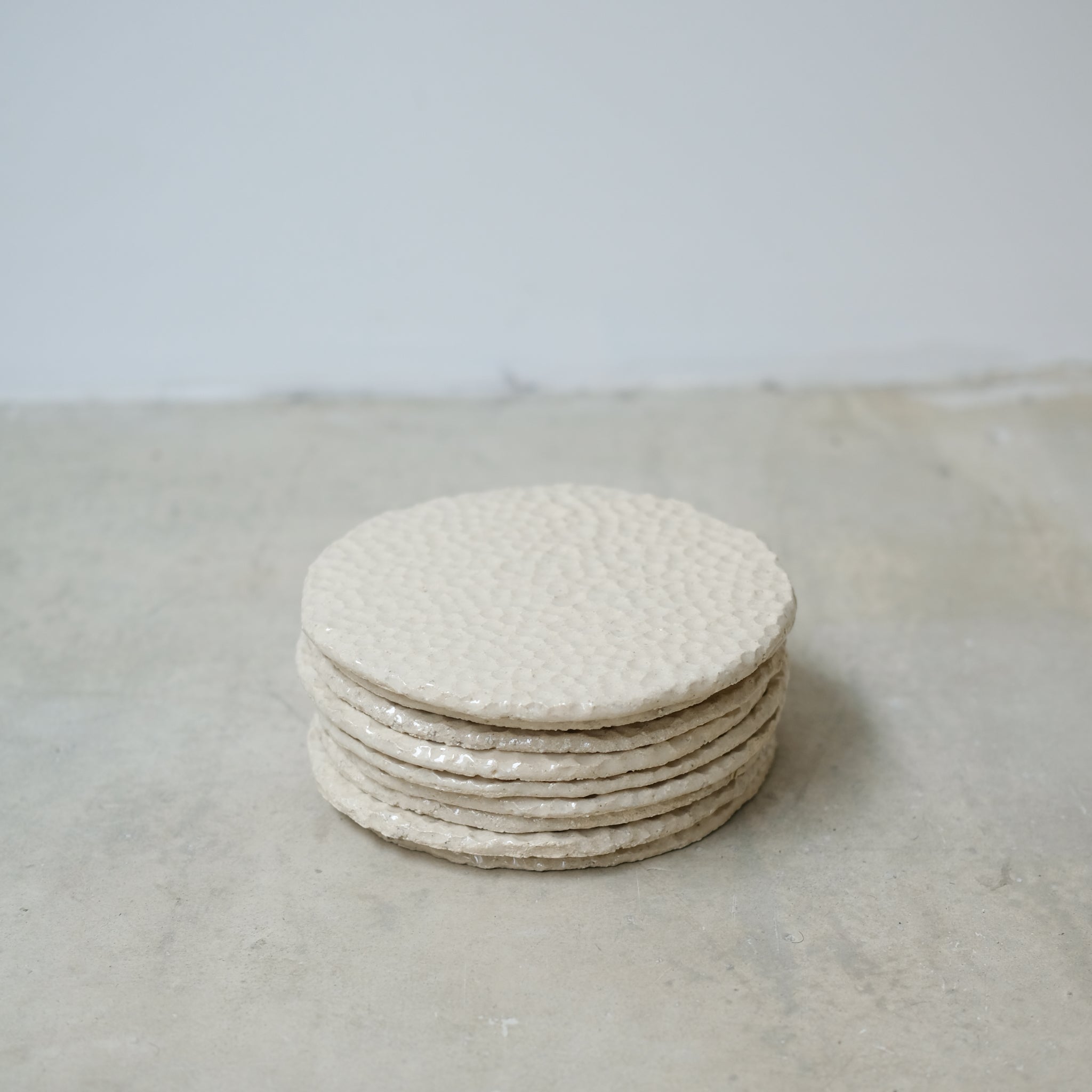 Assiette martelée en grès blanc par Simone Loo chez Brutal Ceramics