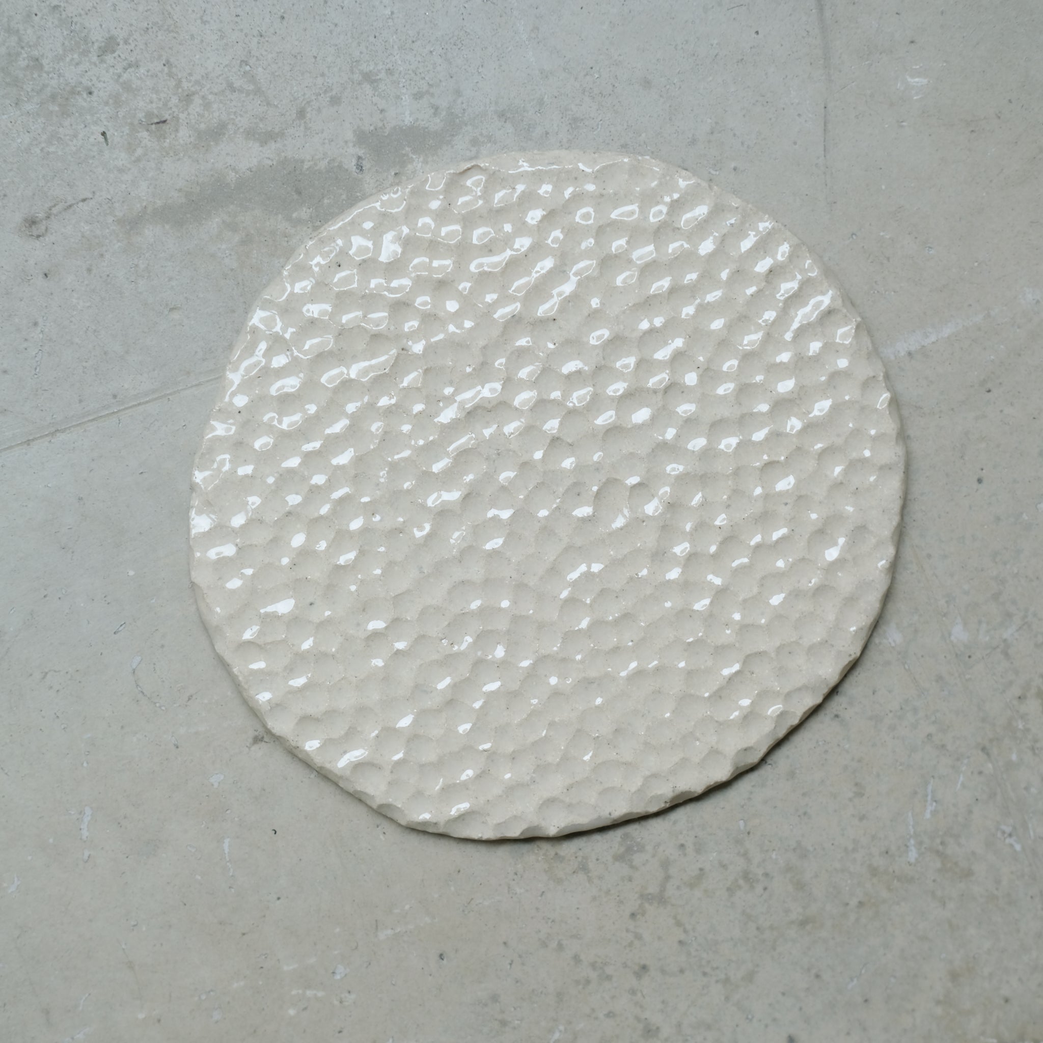 Assiette martelée en grès blanc par Simone Loo chez Brutal Ceramics