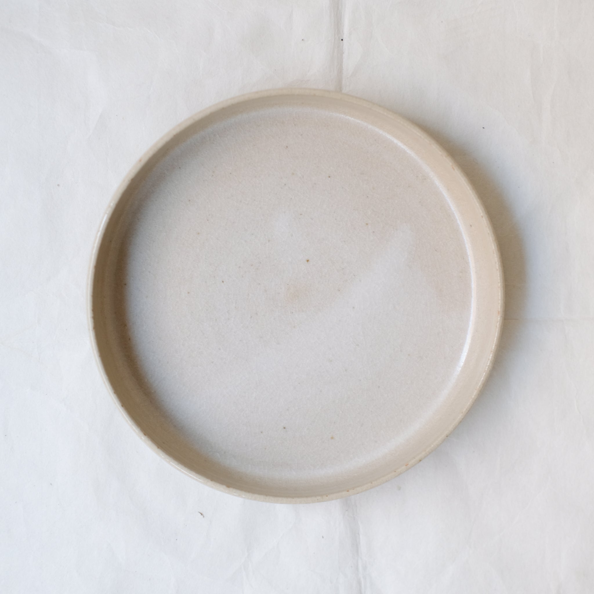 Assiette à rebord beige craquelé par la céramiste Laurence Labbé chez Brutal Ceramics