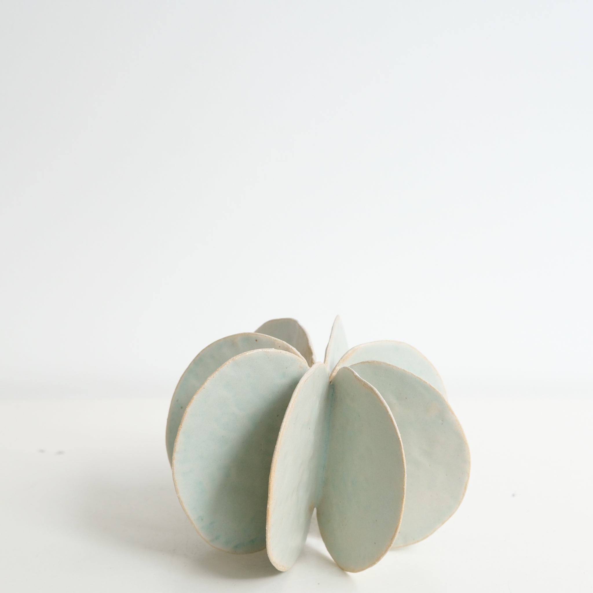 Objet Petale L en grès blanc D 14cm - vert céladon de Motoko Saigo chez Brutal Ceramics