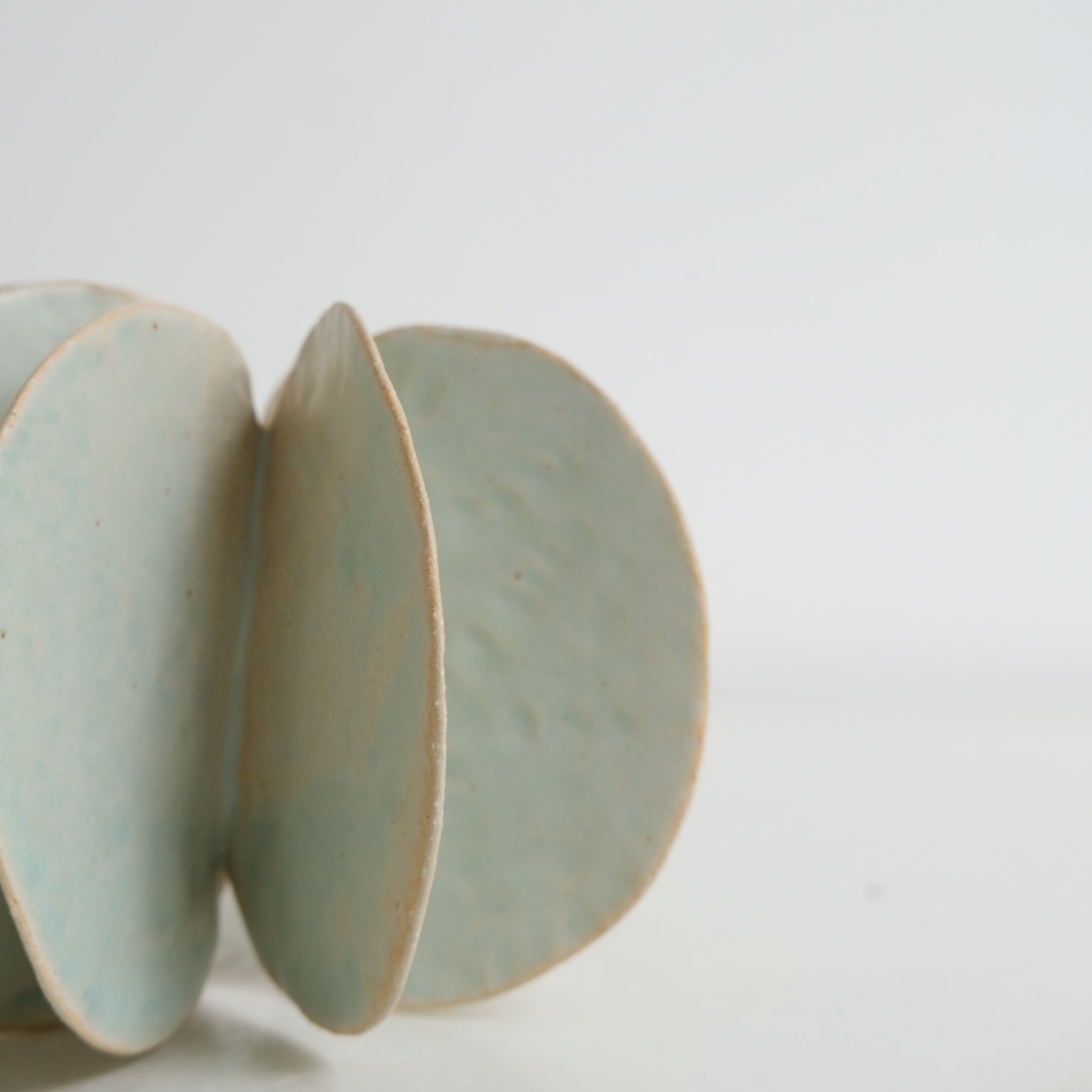 Objet Petale L en grès blanc D 14cm - vert céladon de Motoko Saigo chez Brutal Ceramics