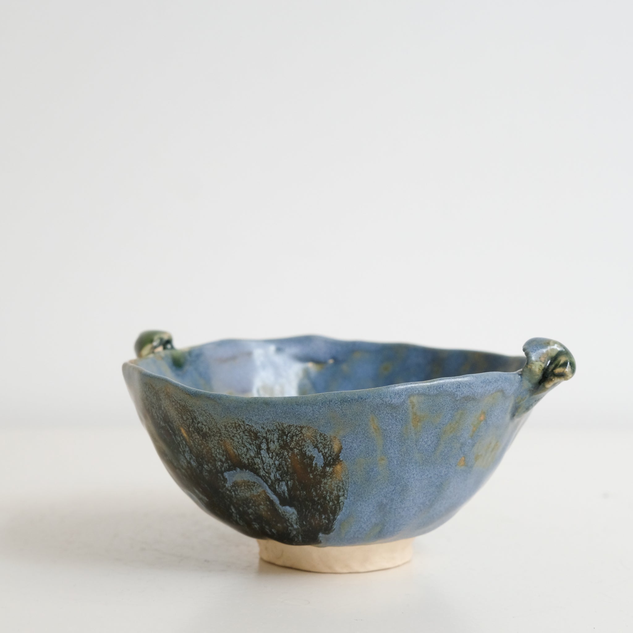 Bol à oreilles en grès blanc D 11cm - bleu-vert et ambre de Cindy Liao Rasamoelina chez Brutal Ceramics