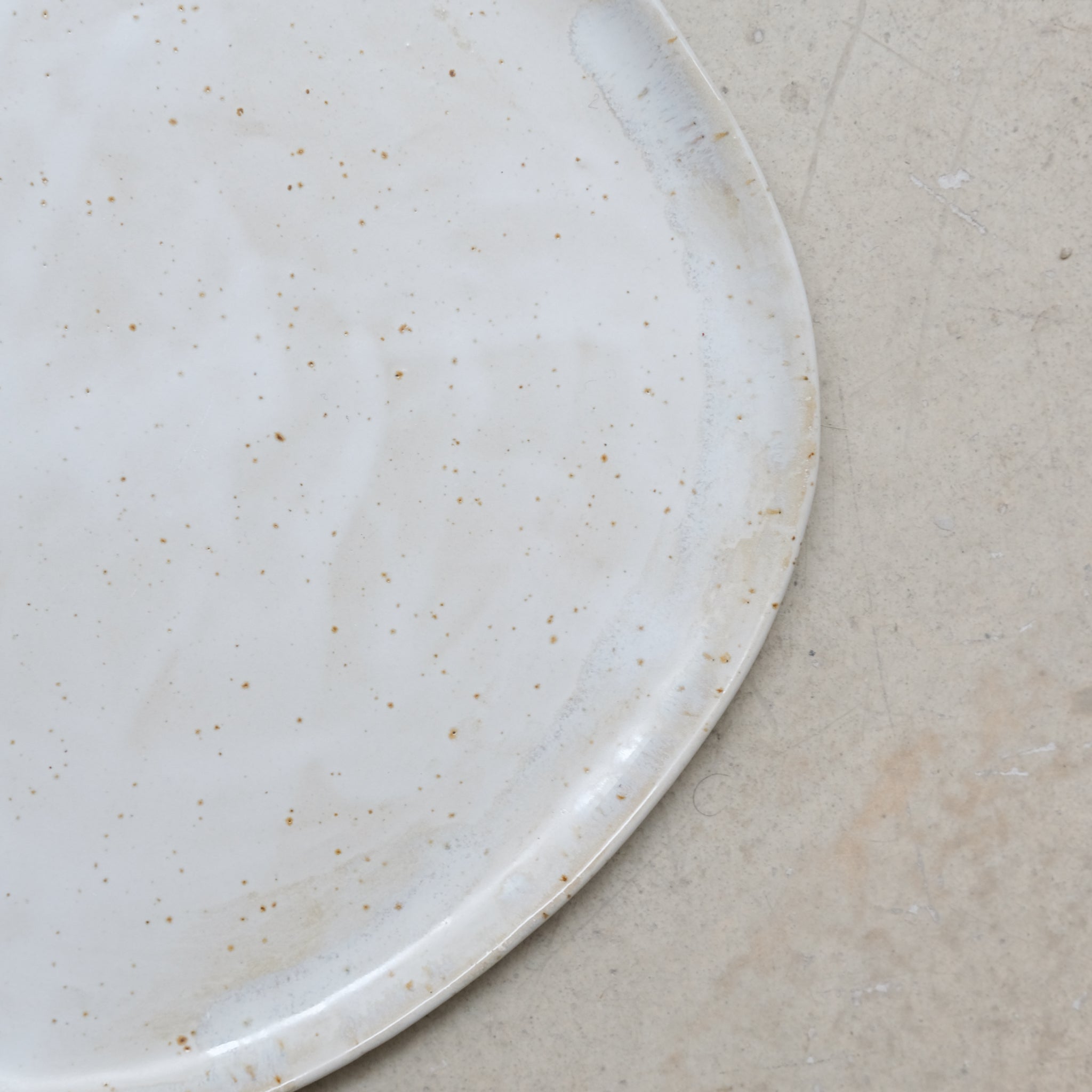 Assiette en grès pyrité D 27cm - blanc moucheté de Sonia Deleani chez Brutal Ceramics