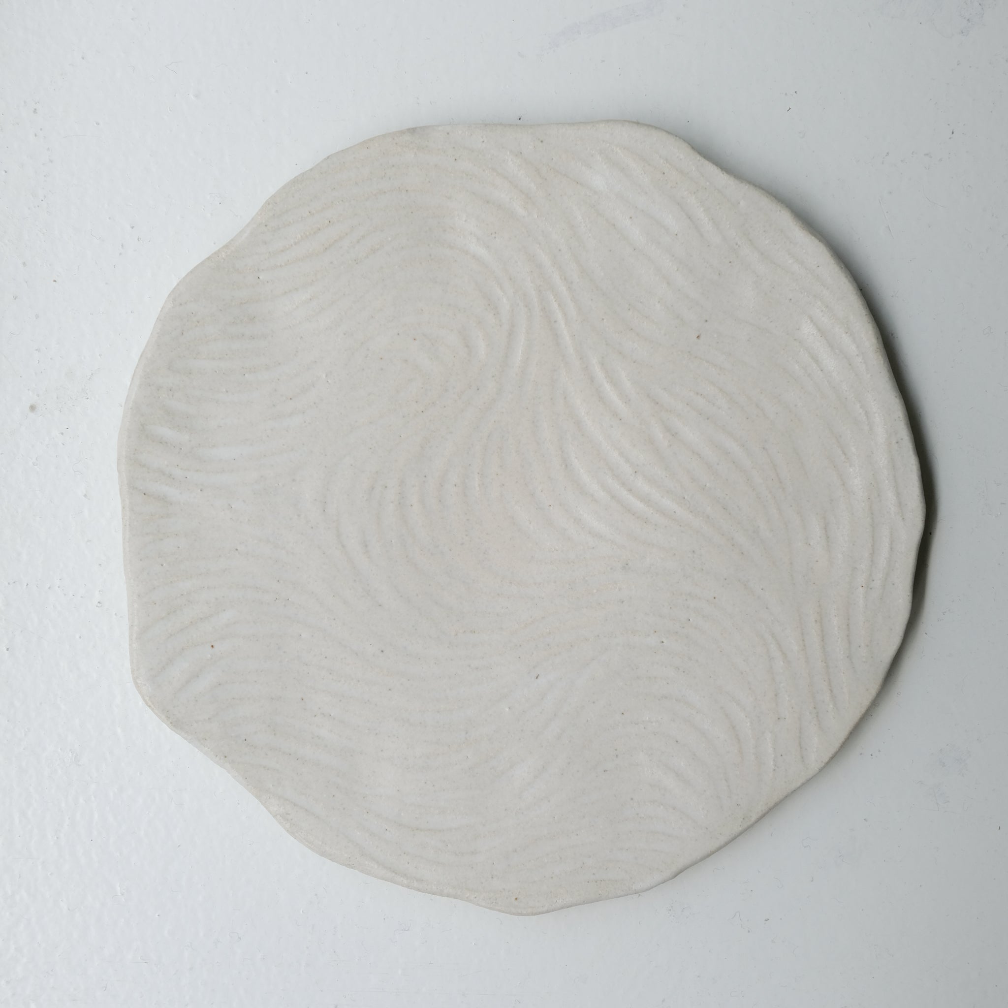 Assiette sur pied en grès D23,5cm- Blanc texturé gravé de Claire Cosnefroy chez Brutal Ceramics