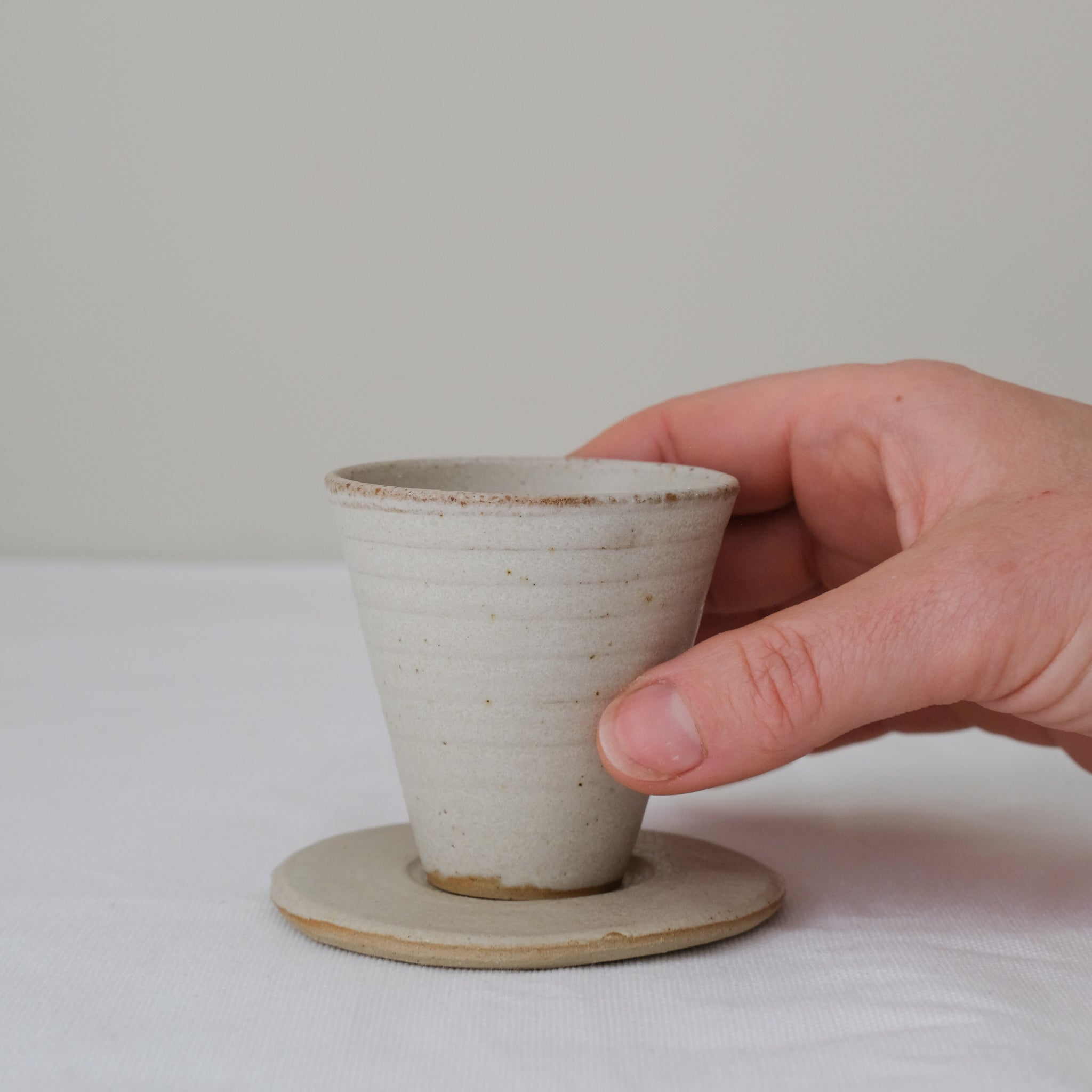 Set soucoupe et tasse en grès blanc 60ml - blanc beige de Louise Traon chez Brutal Ceramics