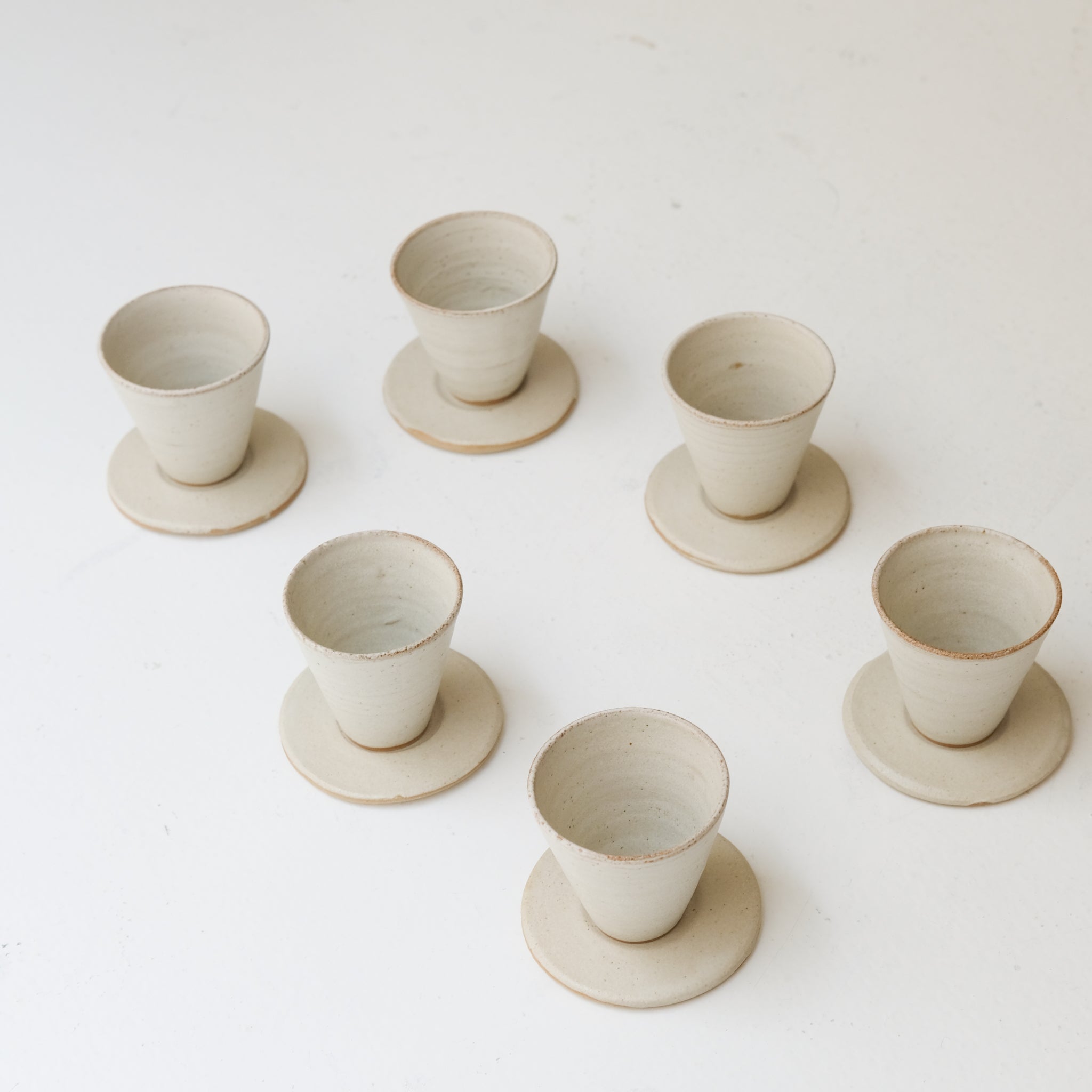 Set soucoupe et tasse en grès blanc 60ml - blanc beige de Louise Traon chez Brutal Ceramics
