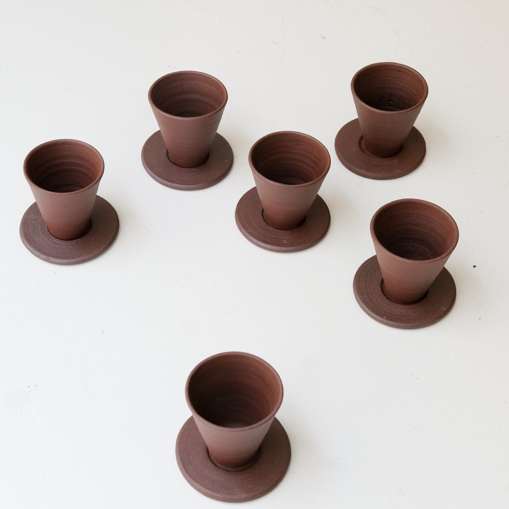 Set soucoupe et tasse en argile recoltée 60ml - rouge foncé mat de Louise Traon chez Brutal Ceramics