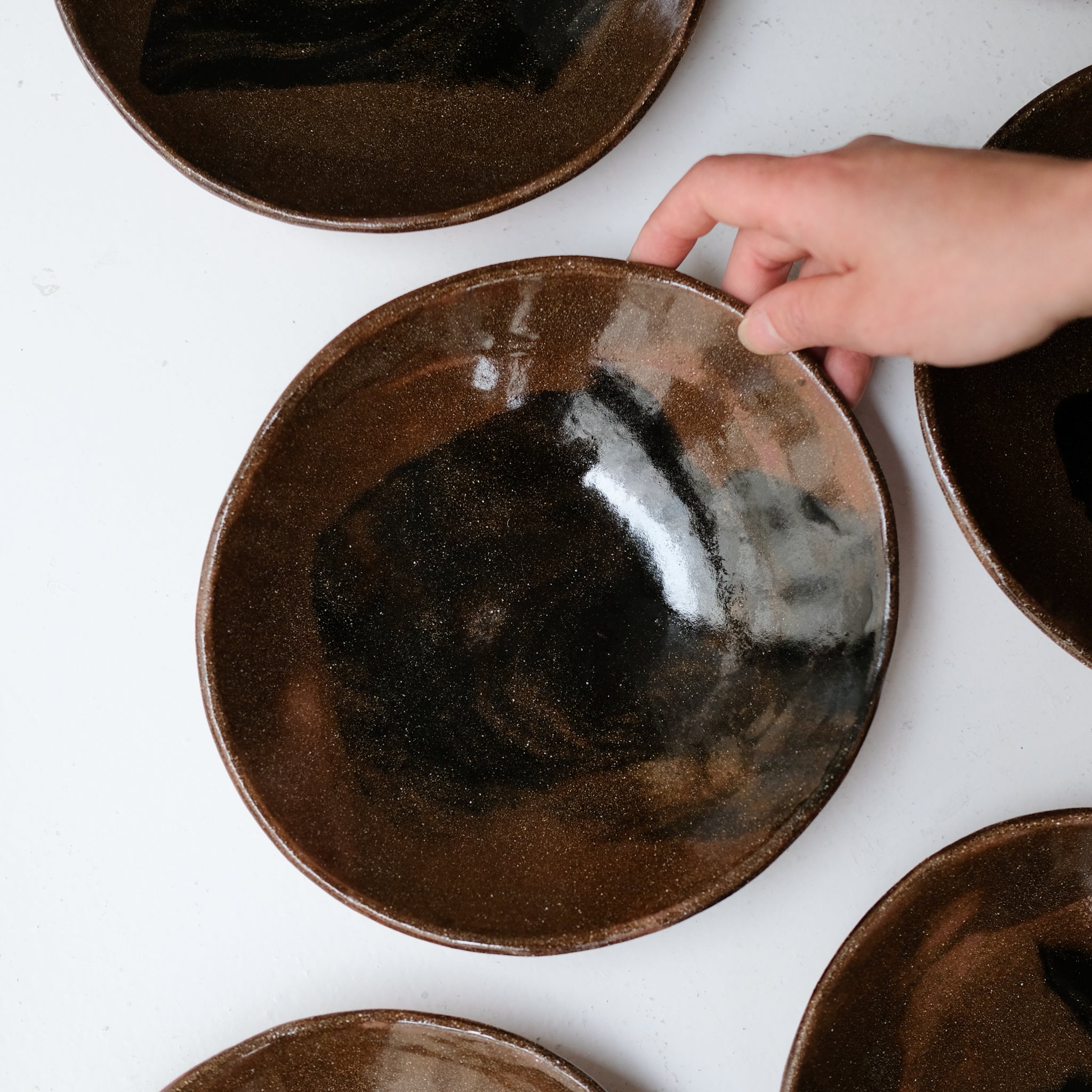 Assiette creuse D 21cm en terres mêlées - noir et brun de Léa Baldassari chez Brutal Ceramics