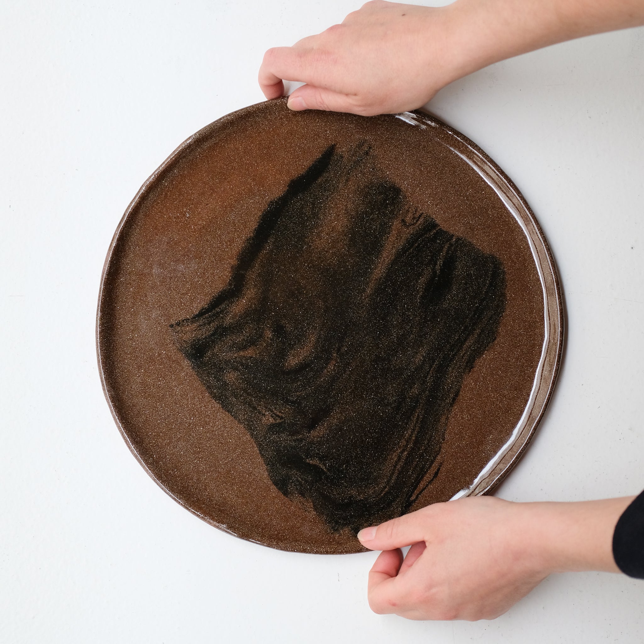 Plat rond D 32cm en terres mêlées - noir et brun de Léa Baldassari chez Brutal Ceramics
