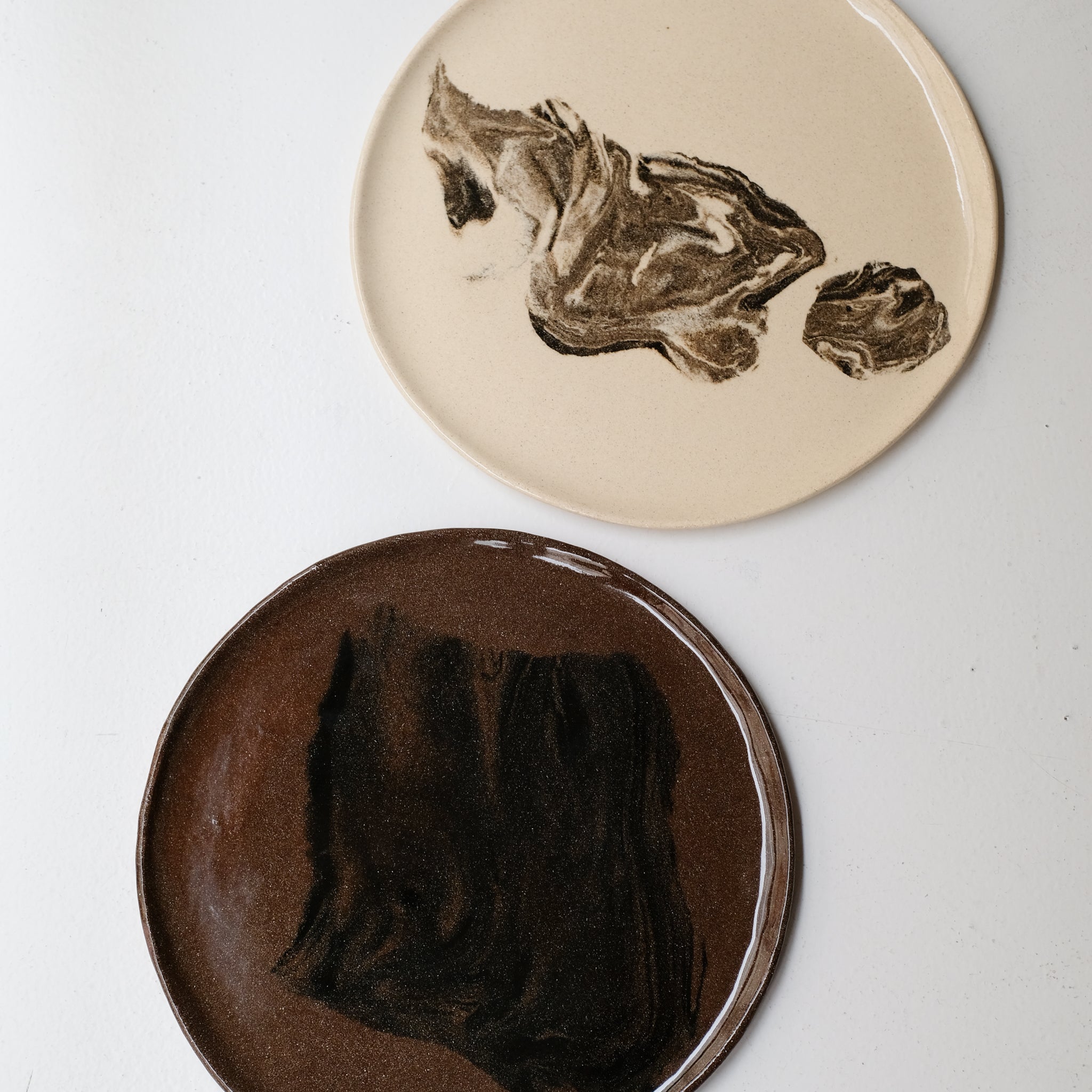 Plat rond D 32cm en terres mêlées - noir et brun de Léa Baldassari chez Brutal Ceramics