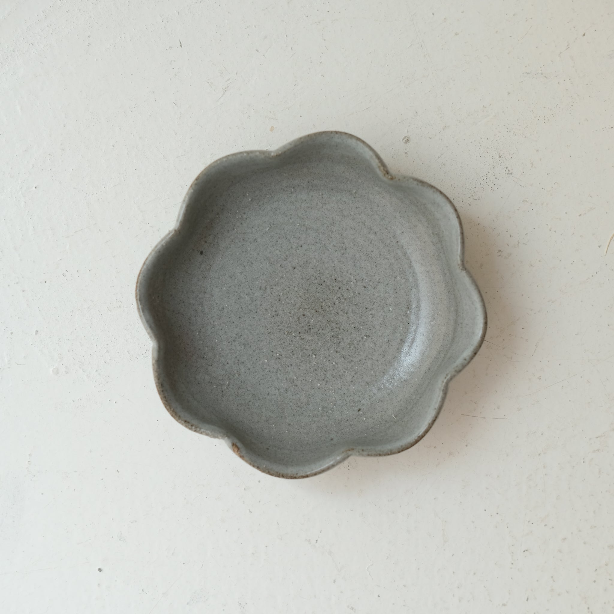 Assiette "fleurs" en grès D 12,5cm - gris clair de Lisa Streich chez Brutal Ceramics