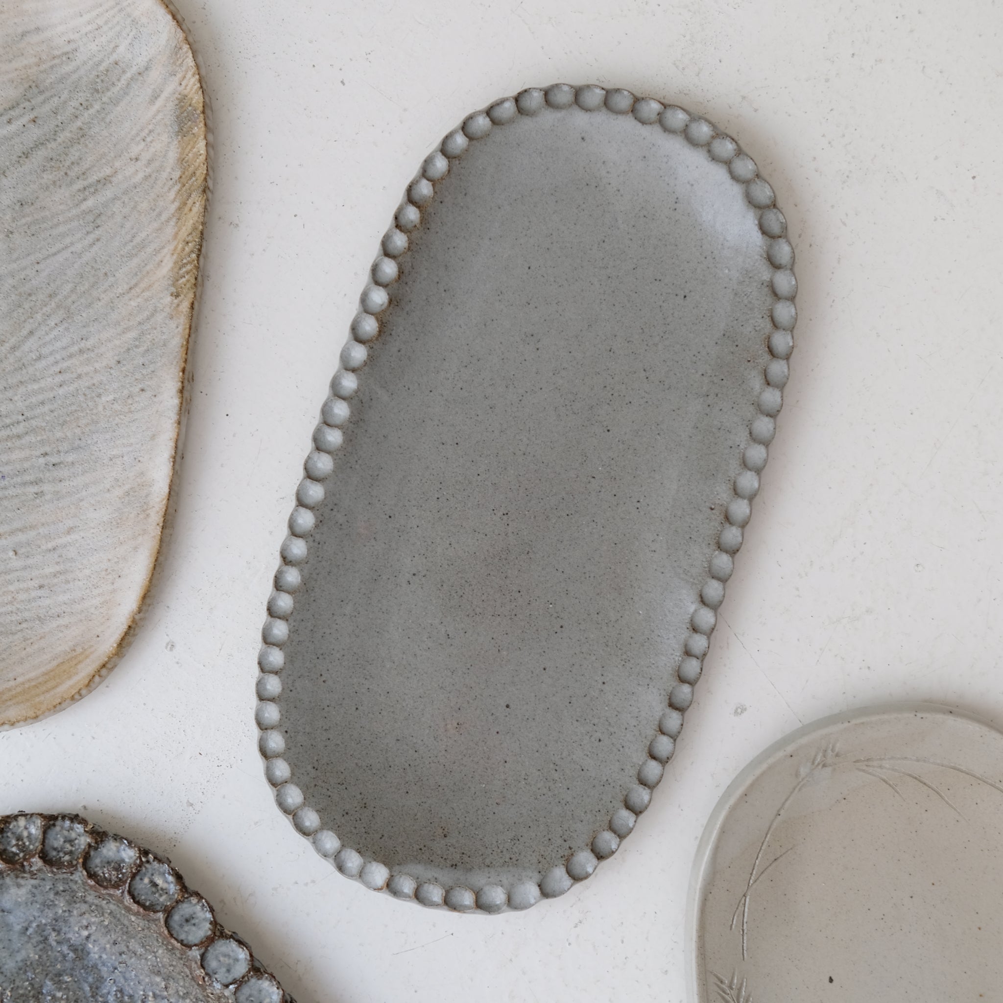 Plat oval cranté en grès L 23cm - gris bleu de Lisa Streich chez Brutal Ceramics