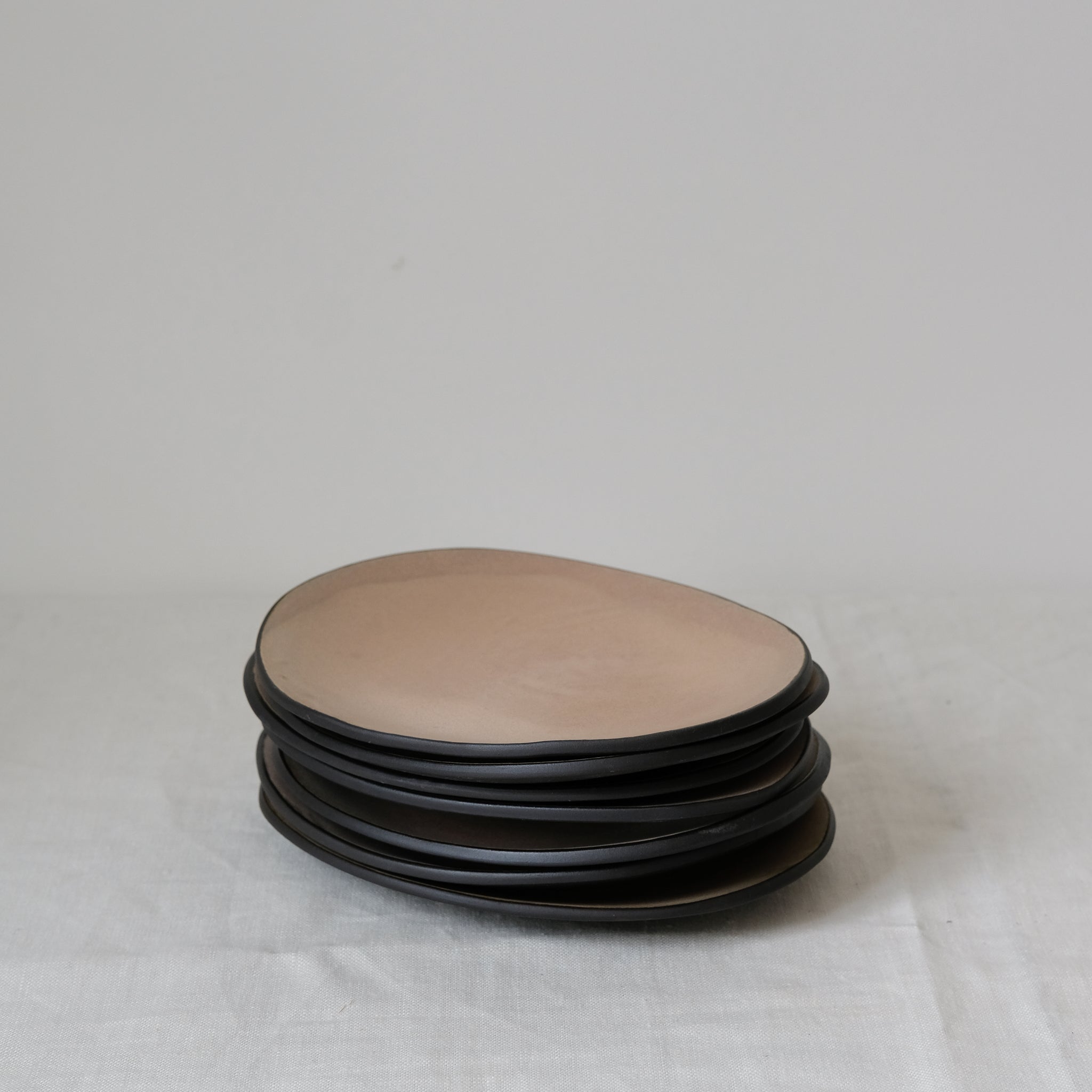 Assiette rose en grès noir L 21cm par Hana Karim chez Brutal Ceramics