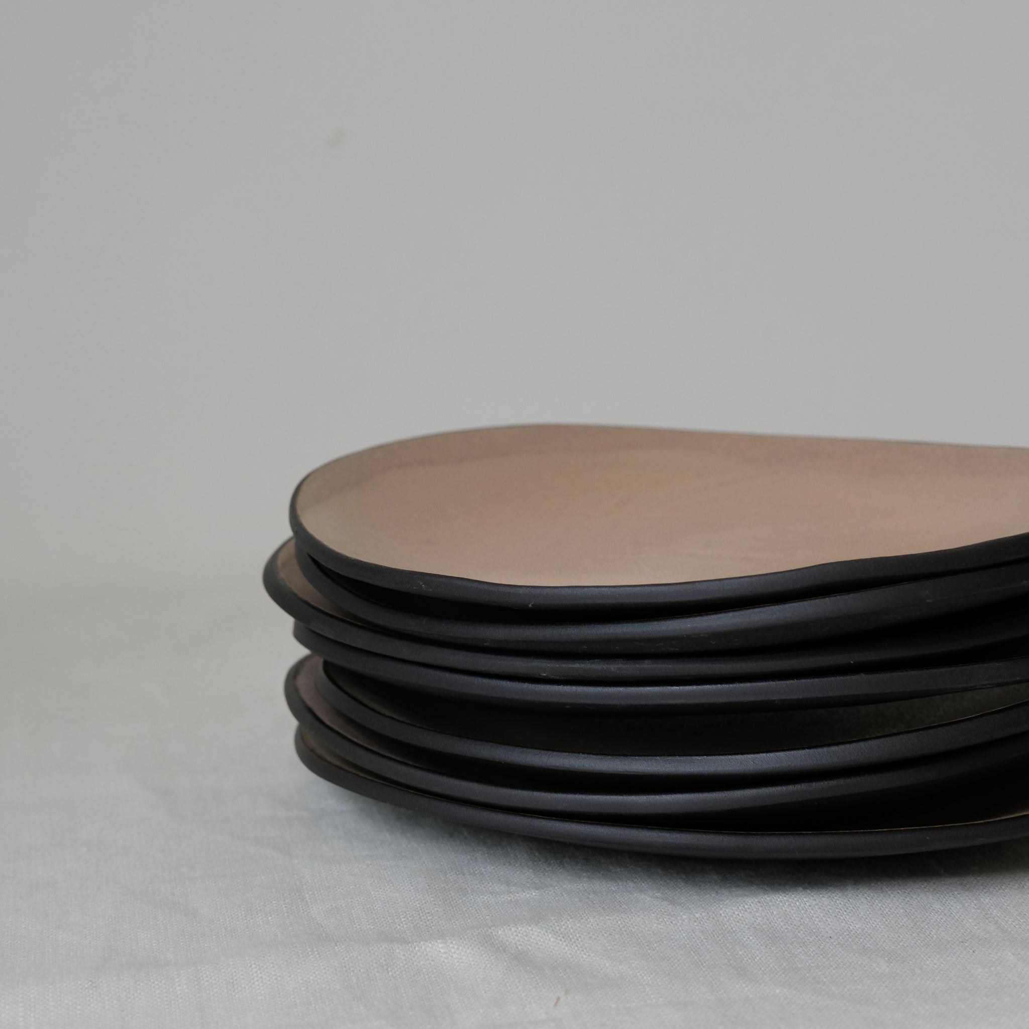 Assiette rose en grès noir L 21cm par Hana Karim chez Brutal Ceramics