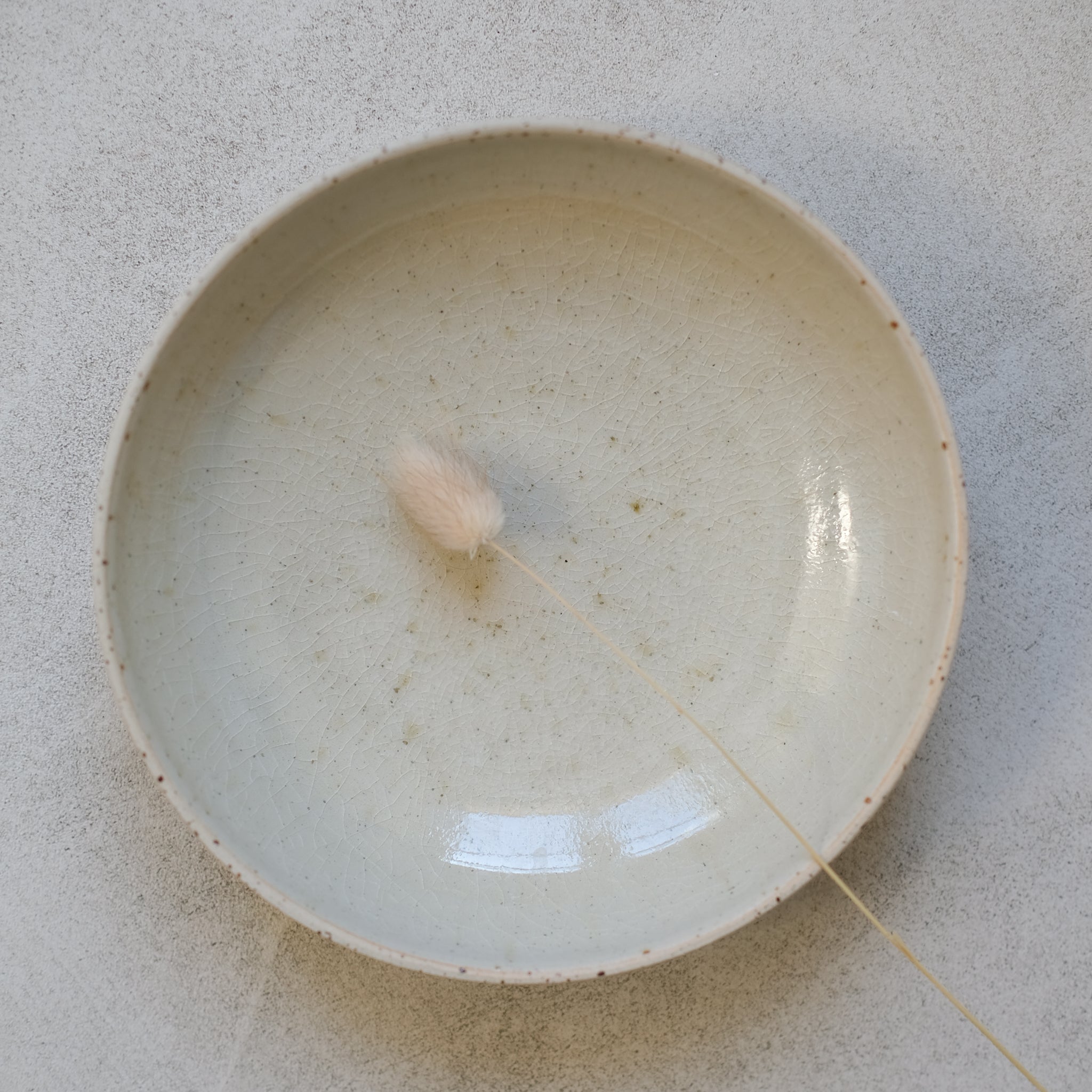 Assiette creuse beige en grès pyrité par Kim Lê chez Brutal Ceramics