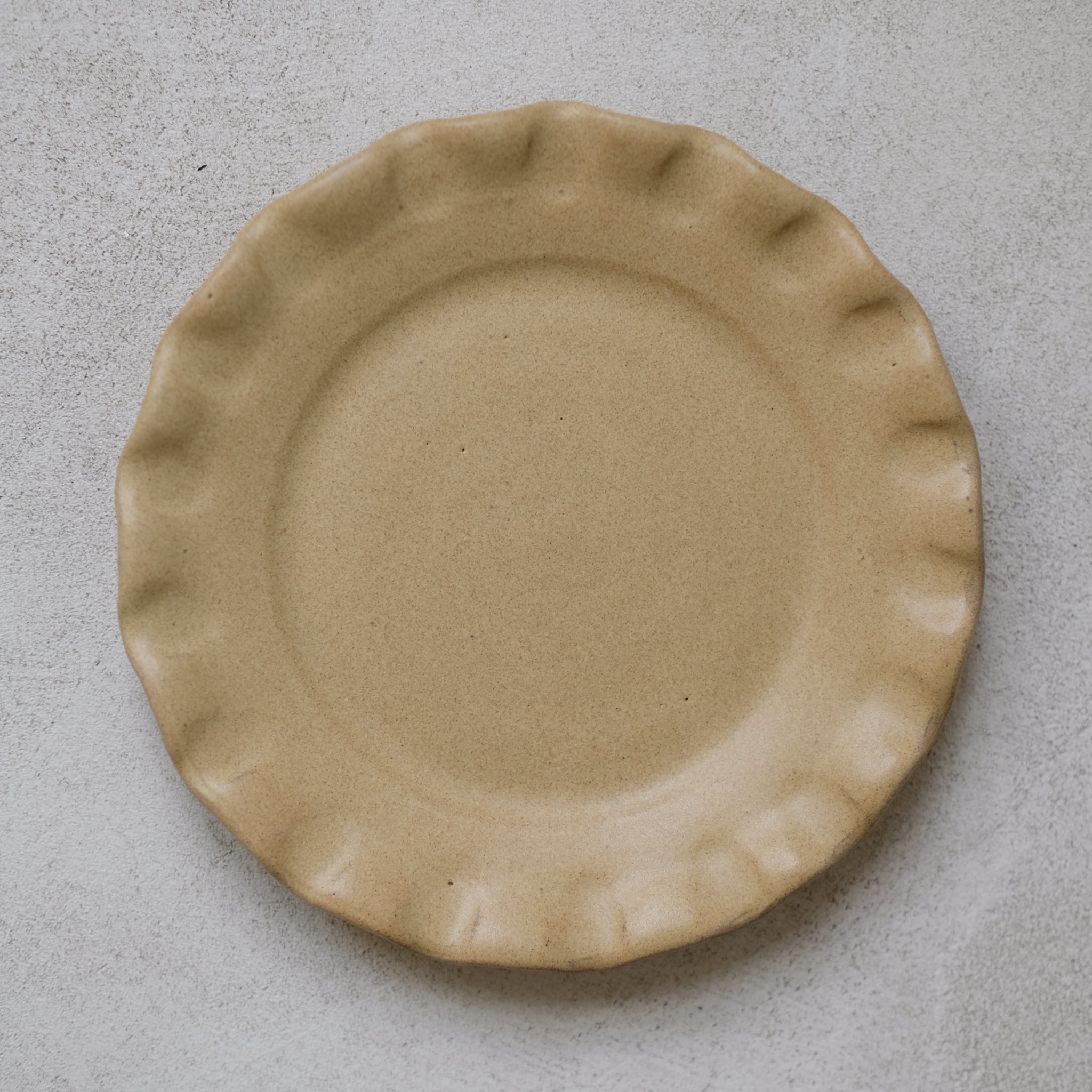 Les assiettes en argile rouge moutarde de Perla Valtierra chez Brutal Ceramics