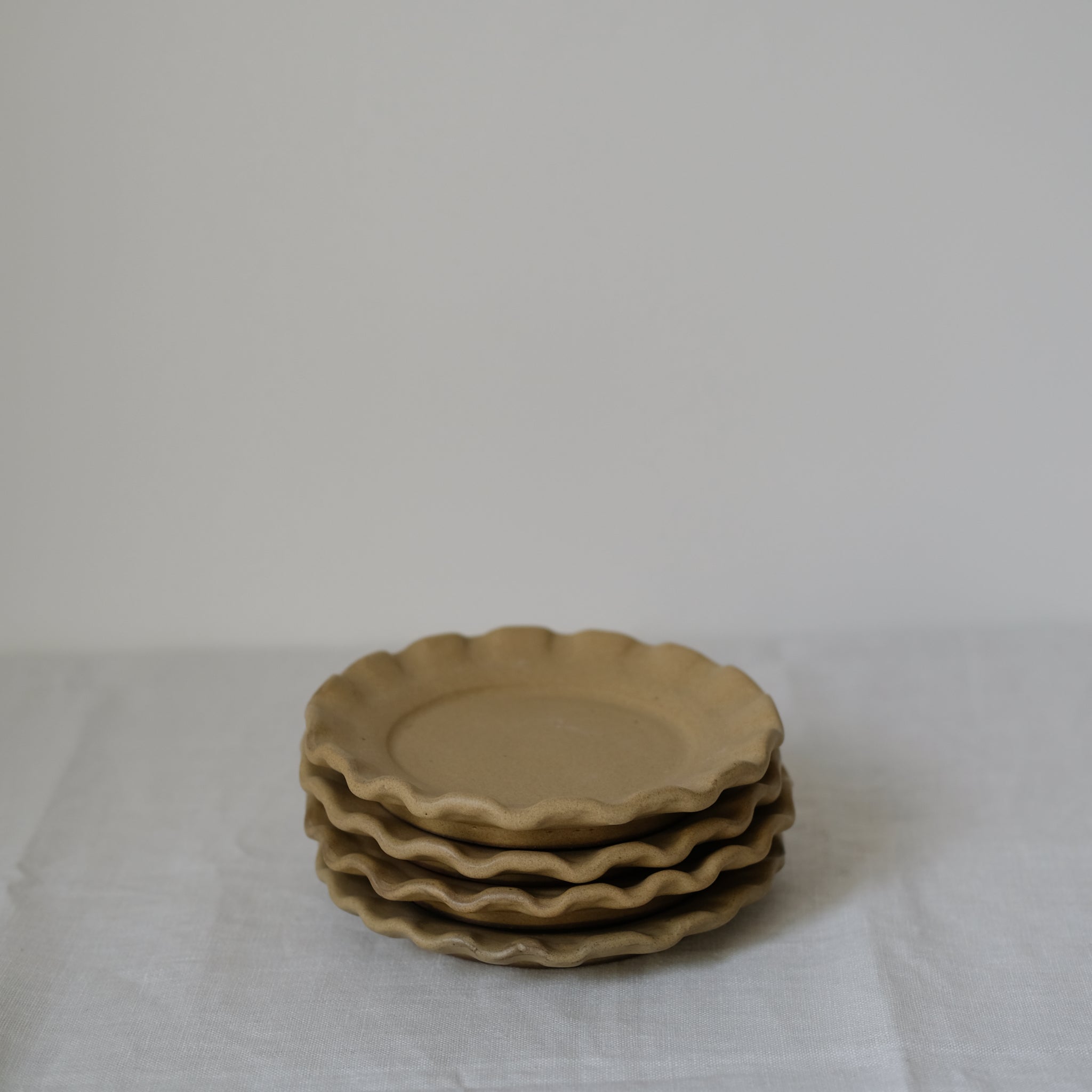 Les assiettes en argile rouge moutarde de Perla Valtierra chez Brutal Ceramics