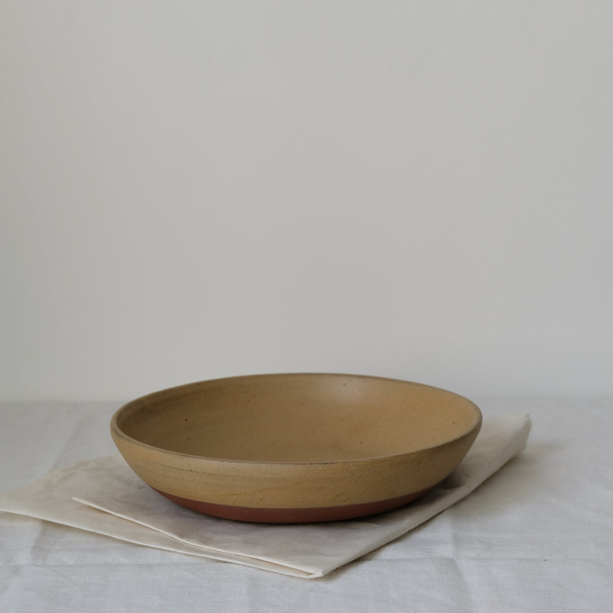 Plat de service en argile moutarde de Perla Valtierra chez Brutal Ceramics