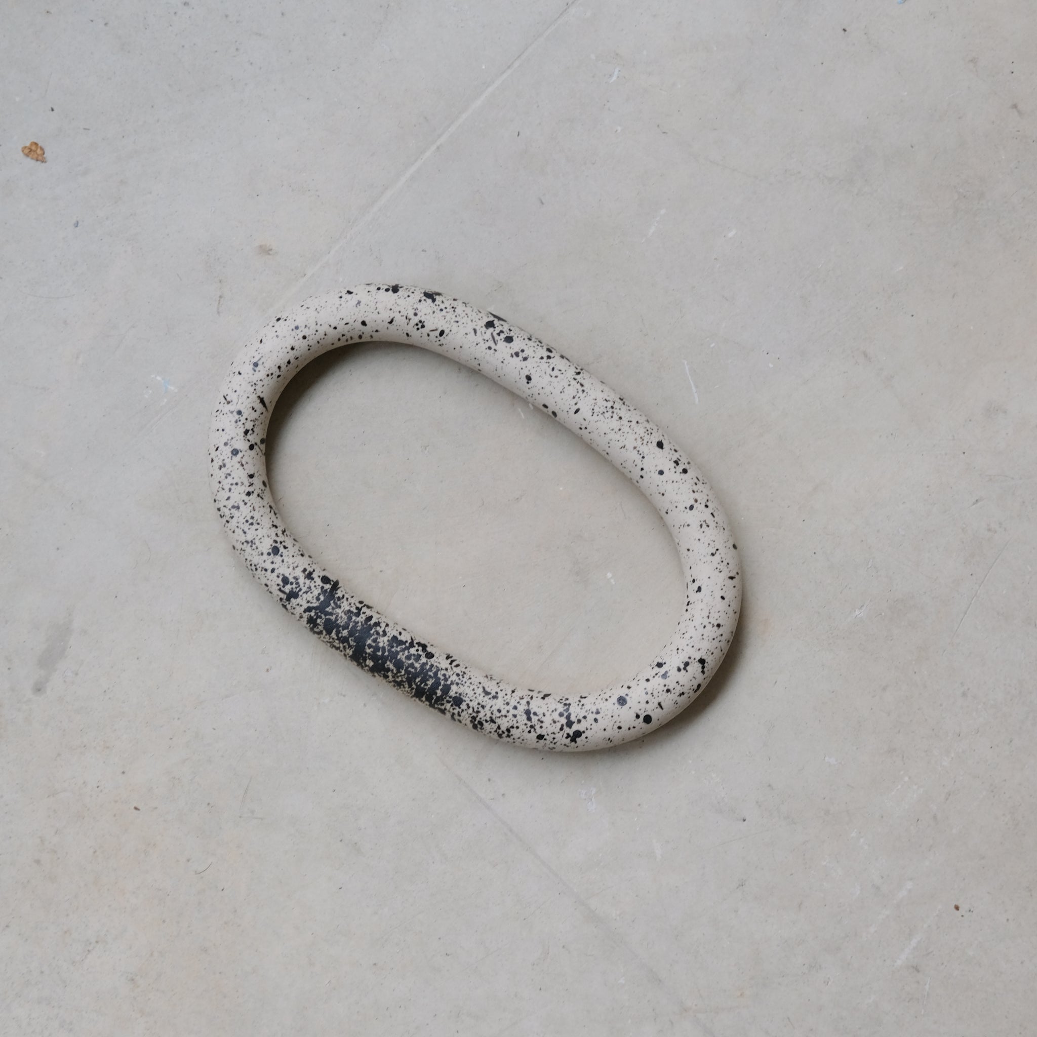 Dessous de plat moucheté noir de Camille Esnée chez Brutal Ceramics