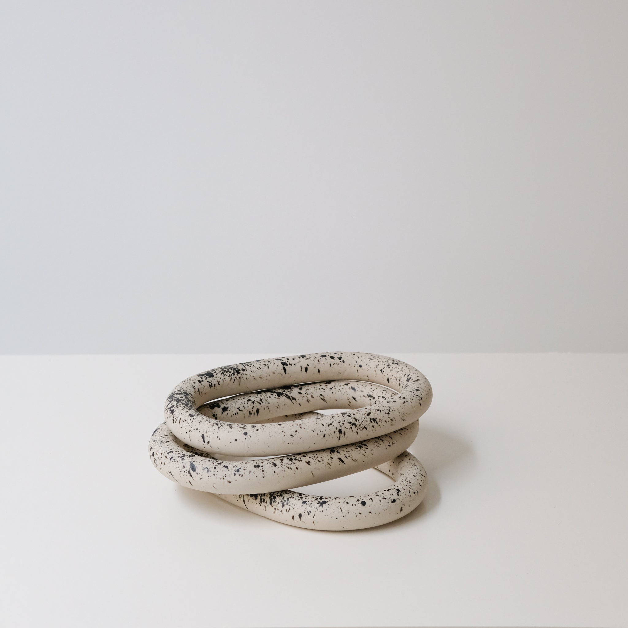 Dessous de plat moucheté noir de Camille Esnée chez Brutal Ceramics