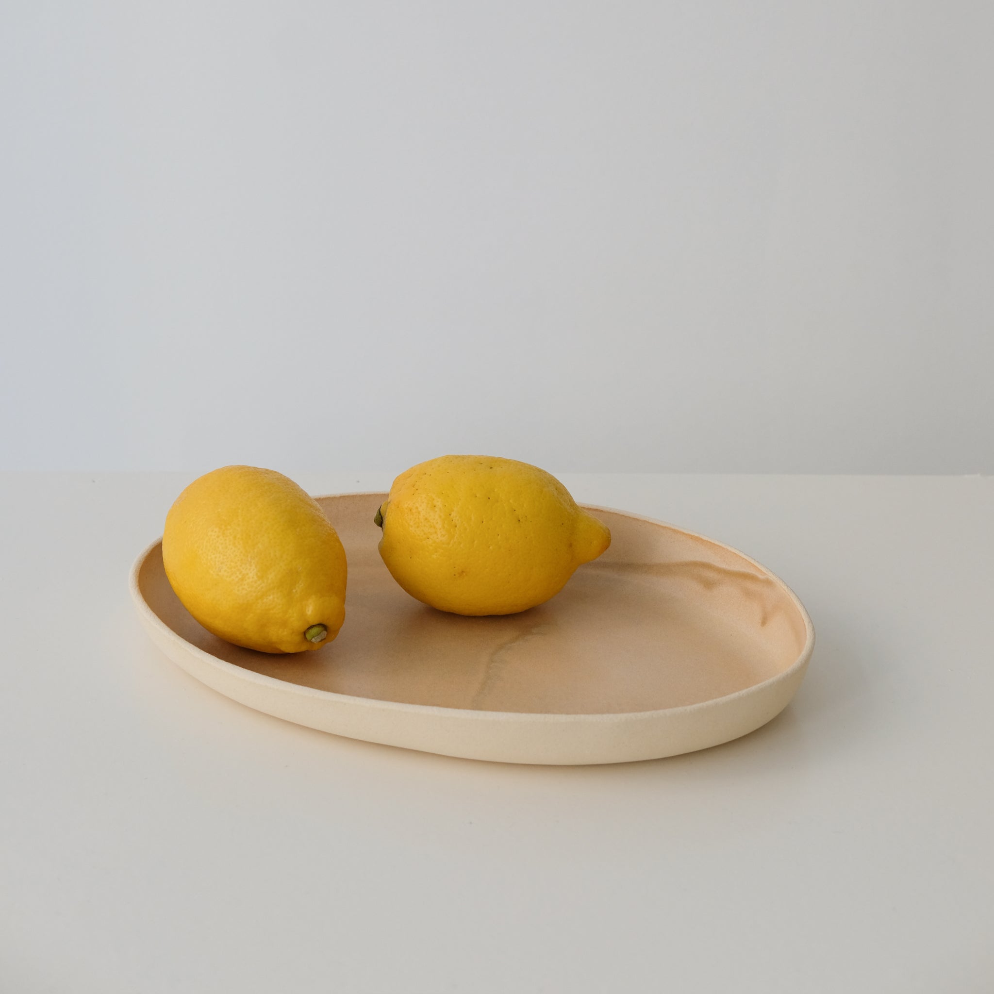 Plat allongé en grès pêche par Lucie Faucon chez Brutal Ceramics