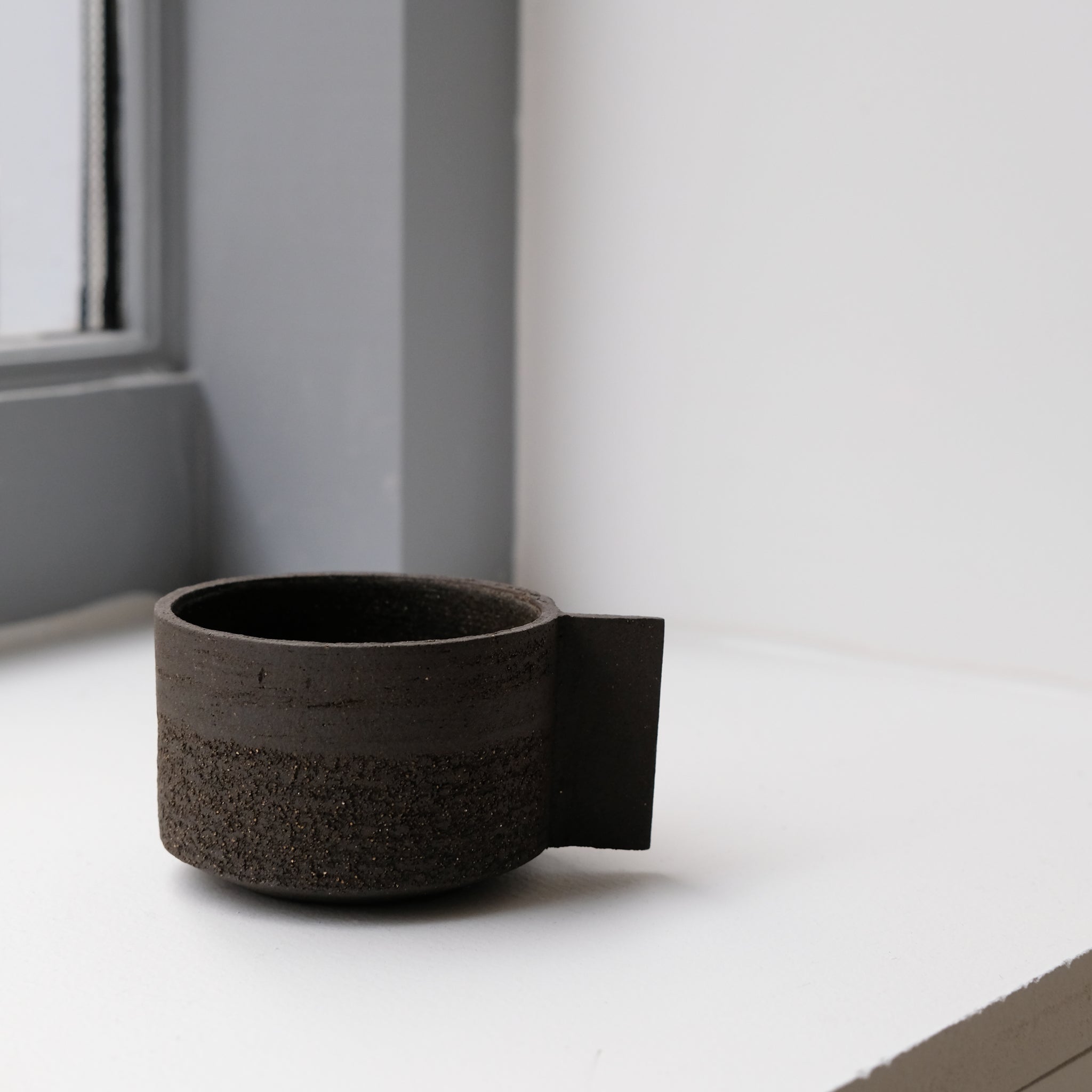Tasse en grès noir chamotté par Studio Racines chez Brutal