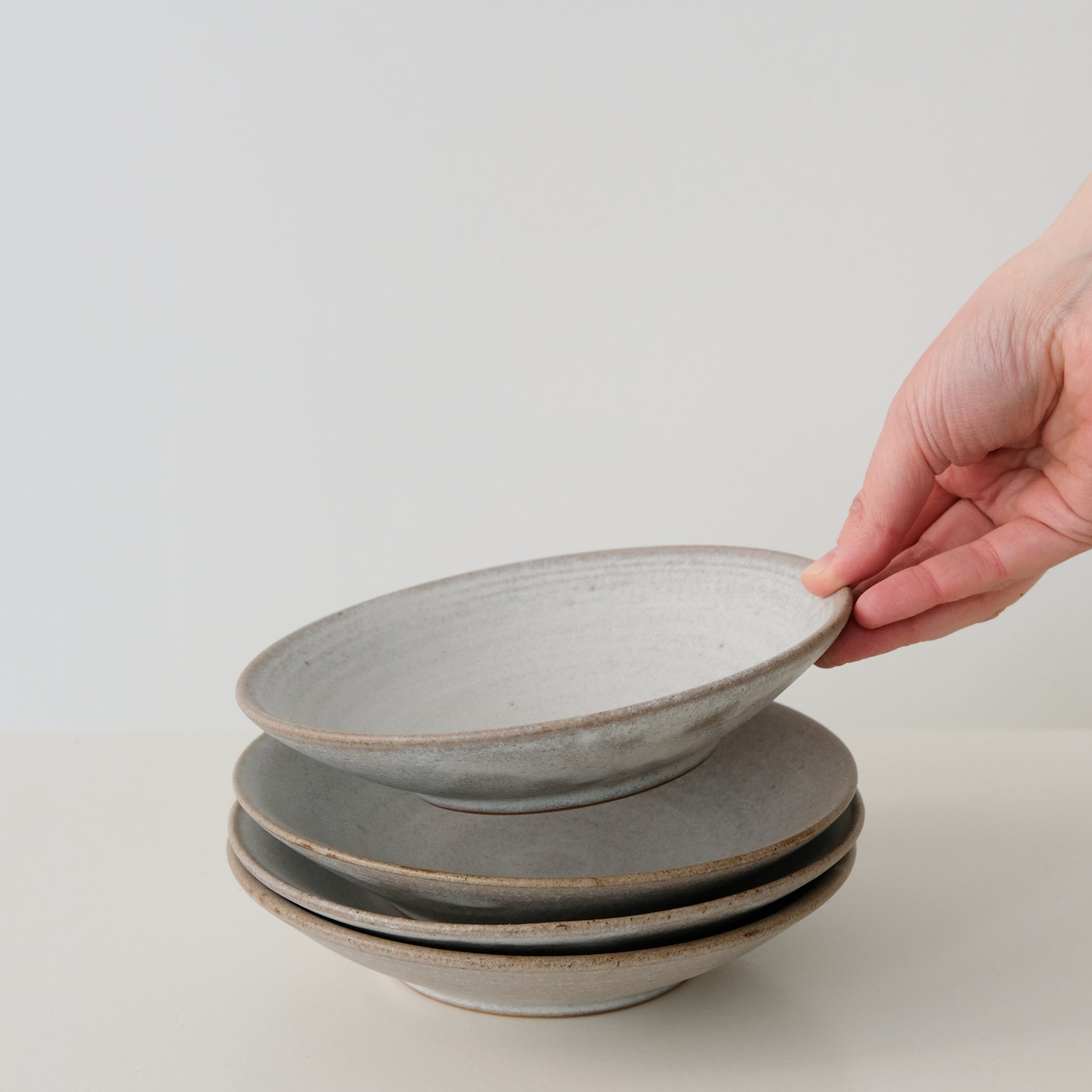 Assiette creuse en grès blanc gris de dunp chez Brutal Ceramics