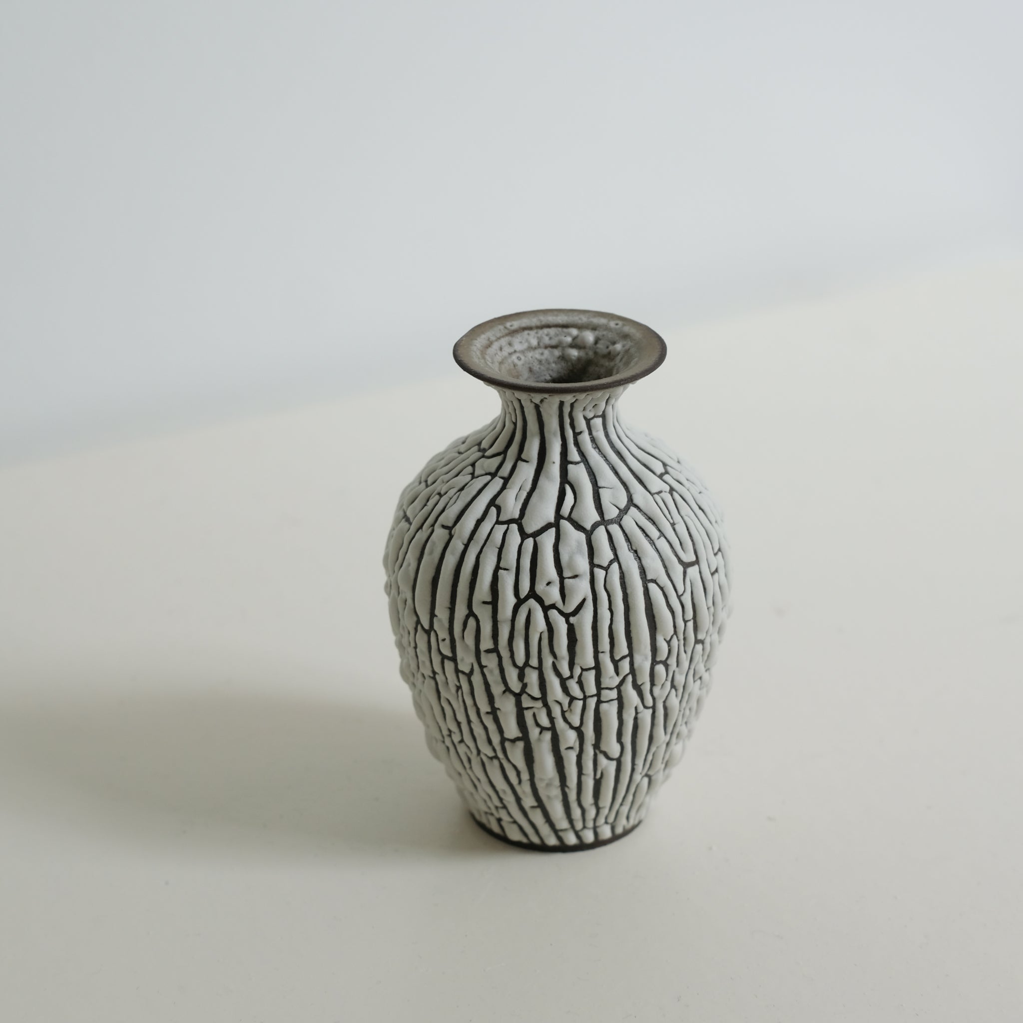 Vase en grès noir H10cm - blanc craquelé de Sharlen Nozawa chez Brutal Ceramics
