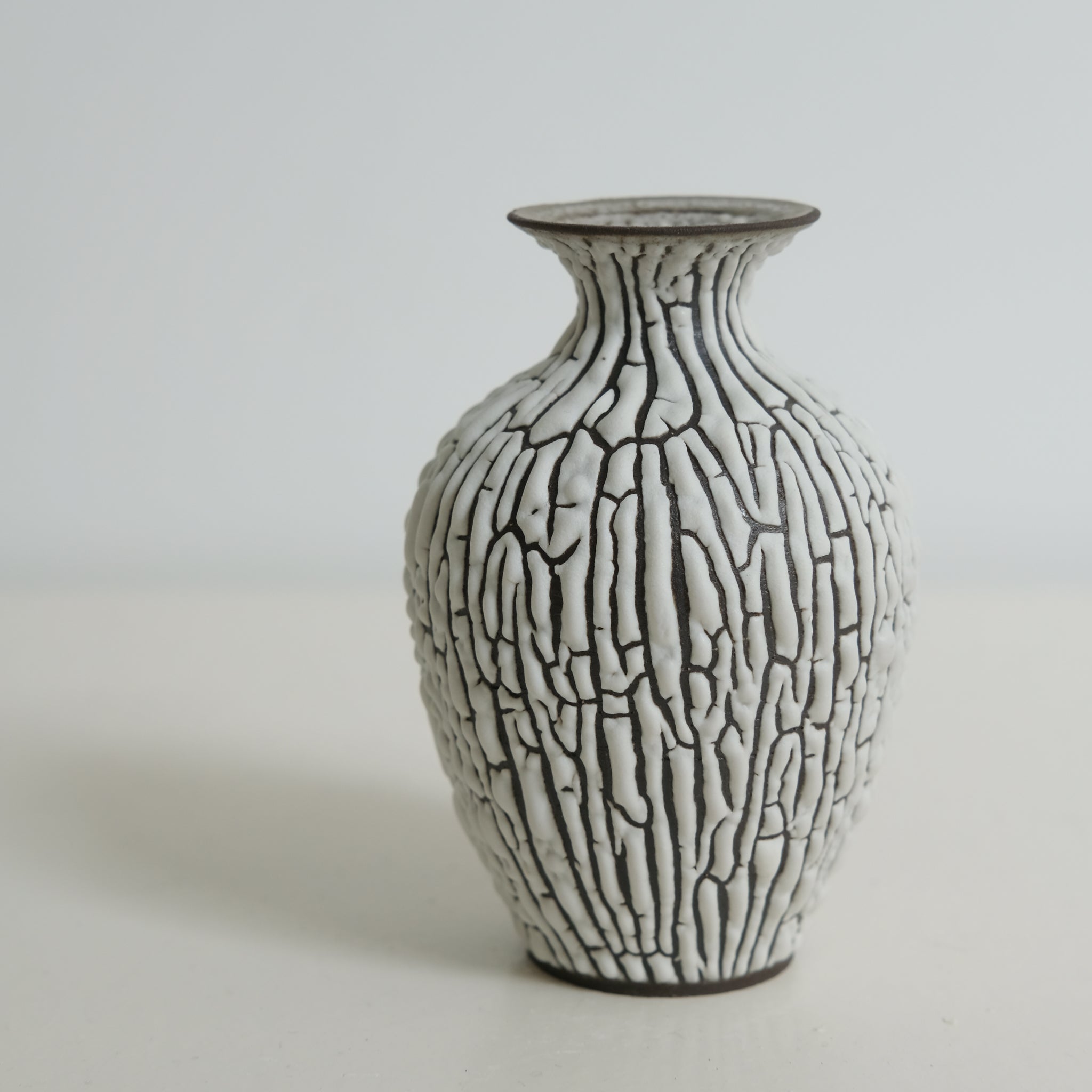 Vase en grès noir H10cm - blanc craquelé de Sharlen Nozawa chez Brutal Ceramics