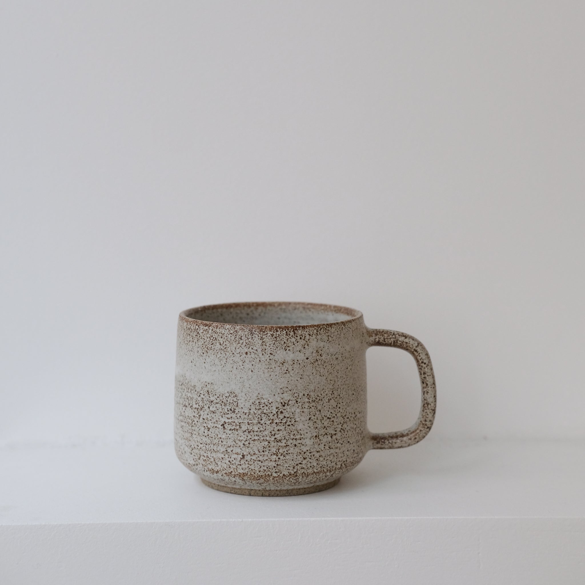 Mug en grès blanc et brun moucheté de Laurence Labbé chez Brutal Ceramics