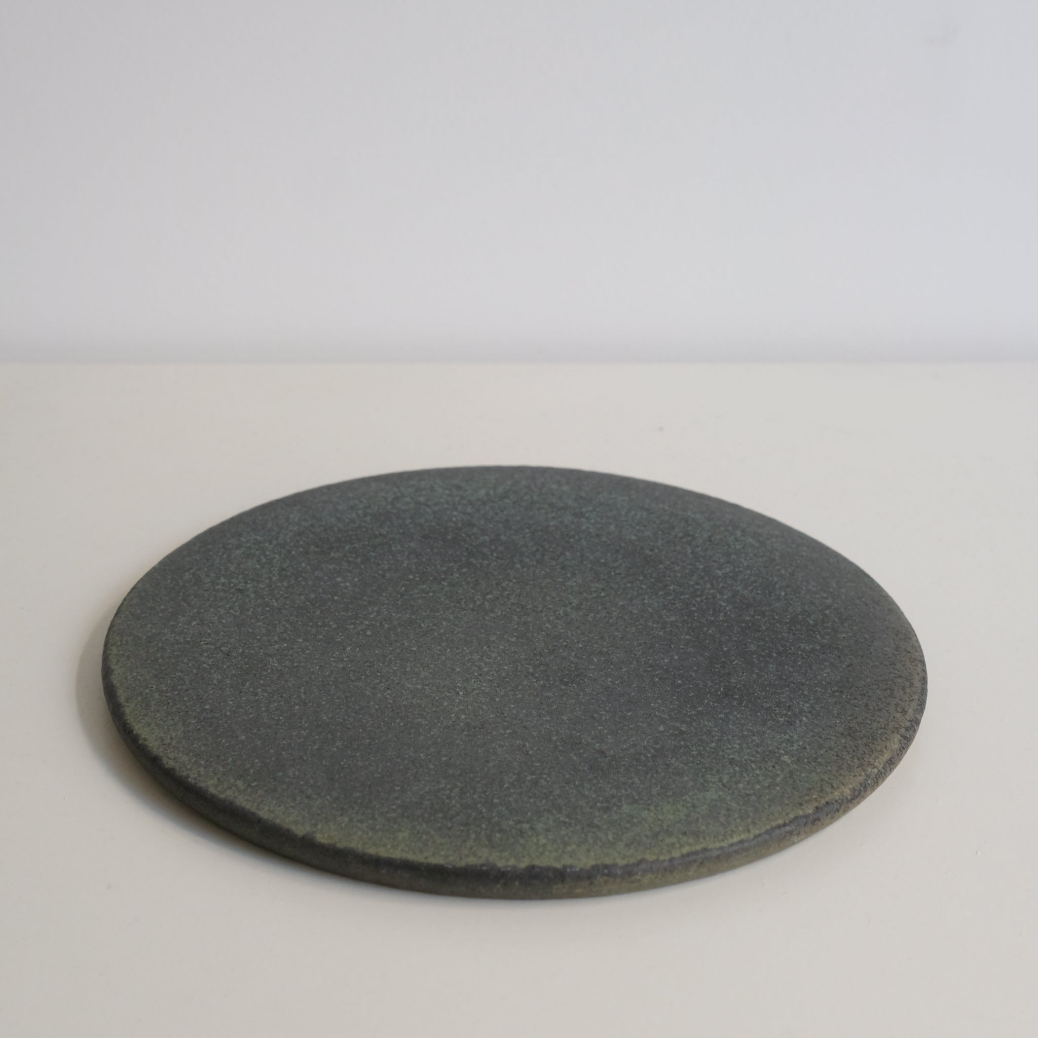 Assiette en grès D 19,5cm vert noir de Mushimegane books. chez Brutal Ceramics