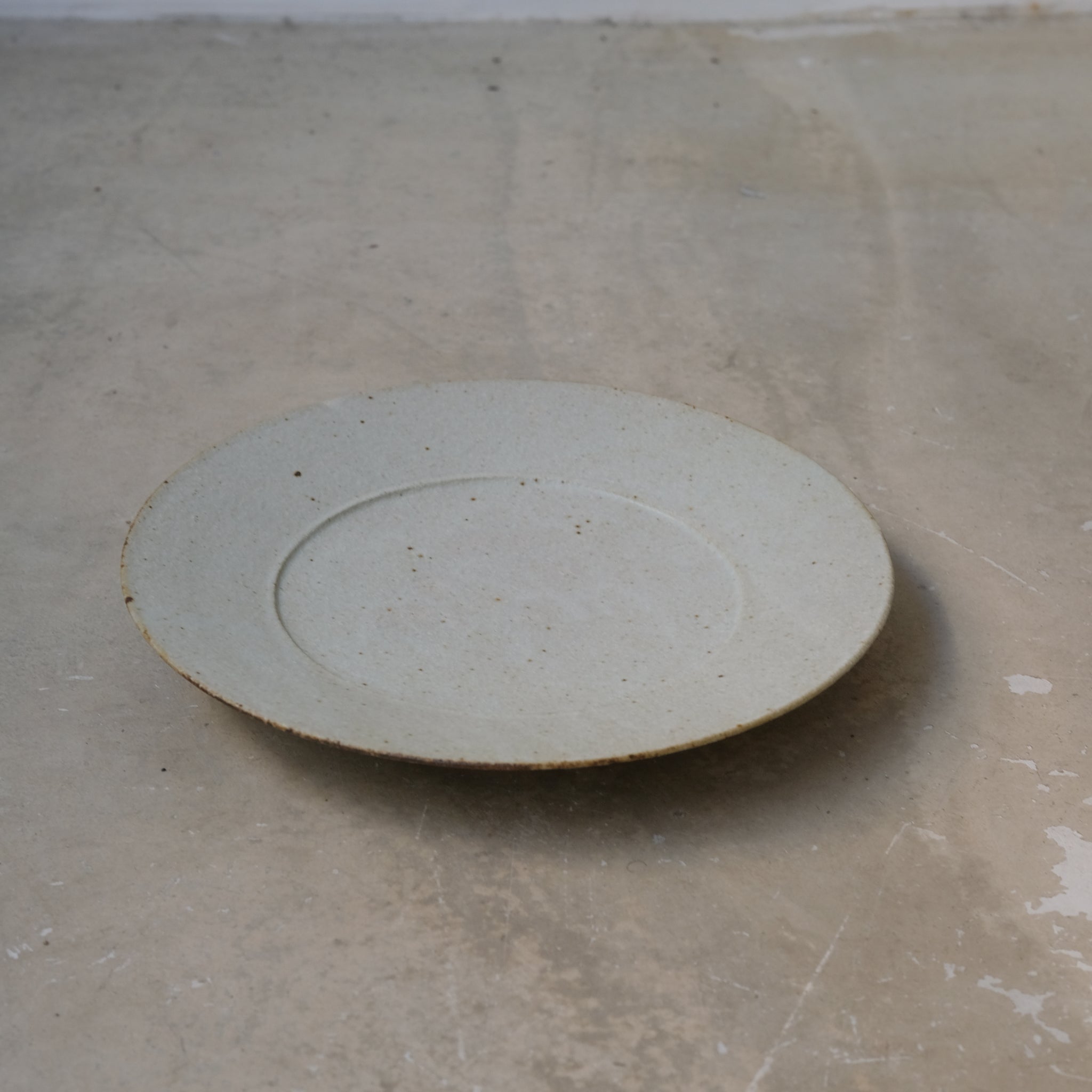 Assiette en grès D 24,5cm - blanc kohiki de Yamato Kobayashi chez Brutal Ceramics