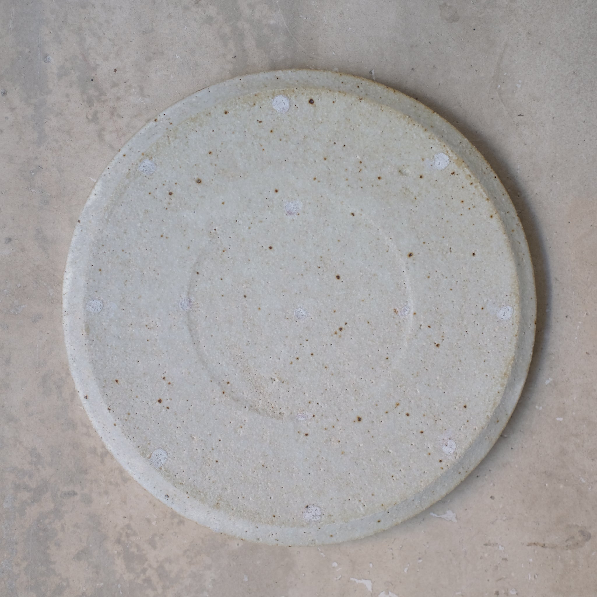 Assiette en grès D 22cm - blanc kohiki de Yamato Kobayashi chez Brutal Ceramics