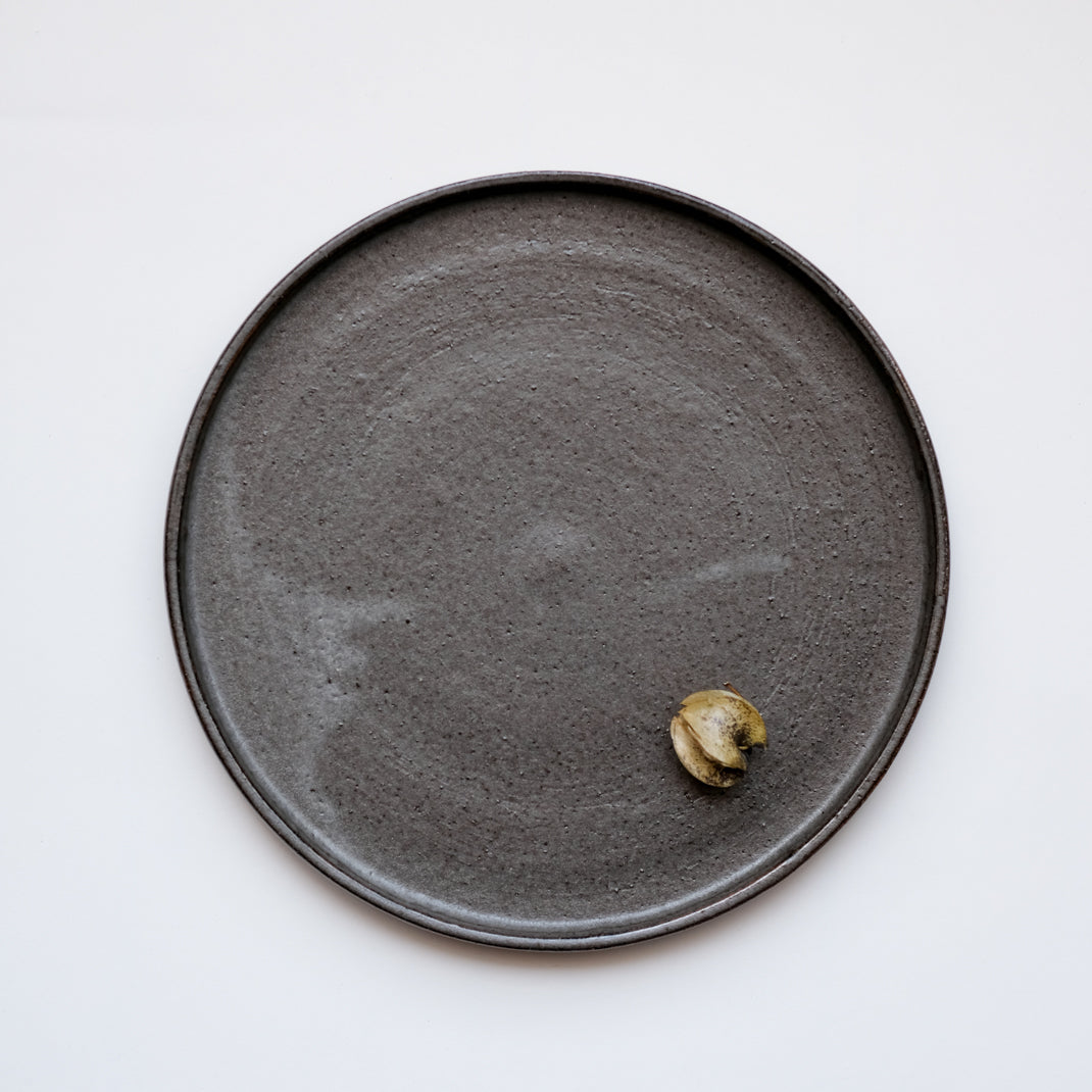 Assiette anthracite réalisée par la céramiste Laurence Labbé chez Brutal Ceramics