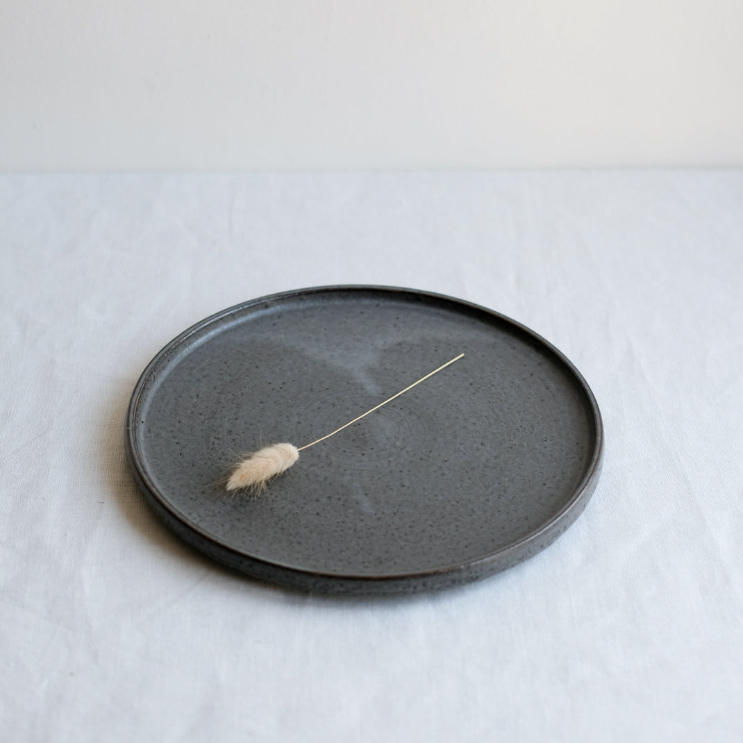 Assiette anthracite réalisée par la céramiste Laurence Labbé chez Brutal Ceramics