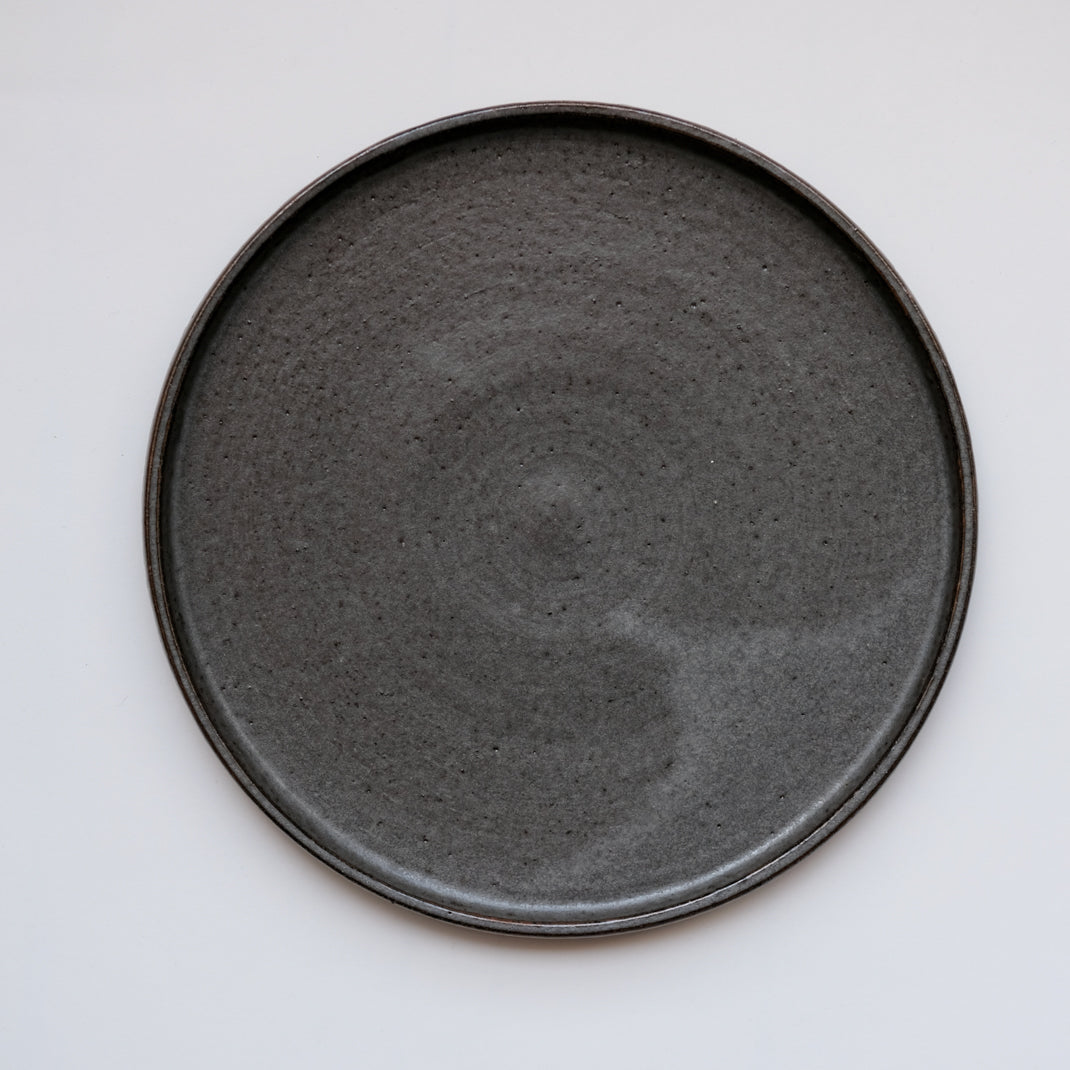Assiette anthracite réalisée par la céramiste Laurence Labbé chez Brutal Ceramics
