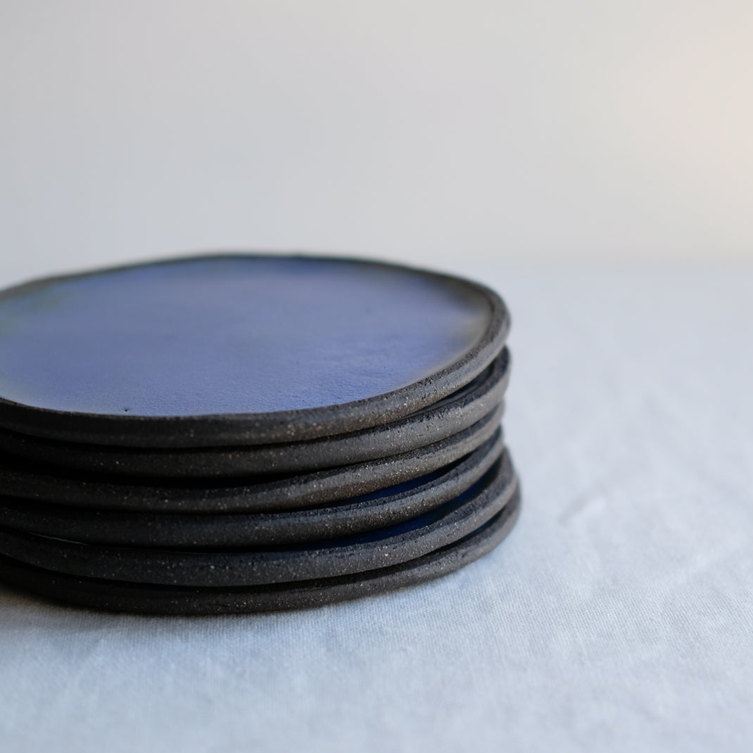 Assiette bleue en grès noir réalisée à la main par Lola Moreau chez Brutal Ceramics