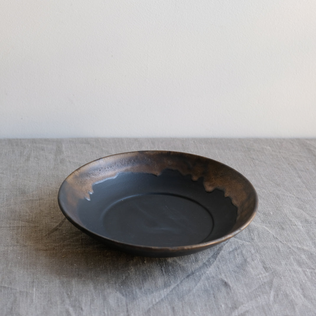 Assiette creuse noire en porcelaine par la céramiste japonaise Narumi Yashiro chez Brutal Ceramics