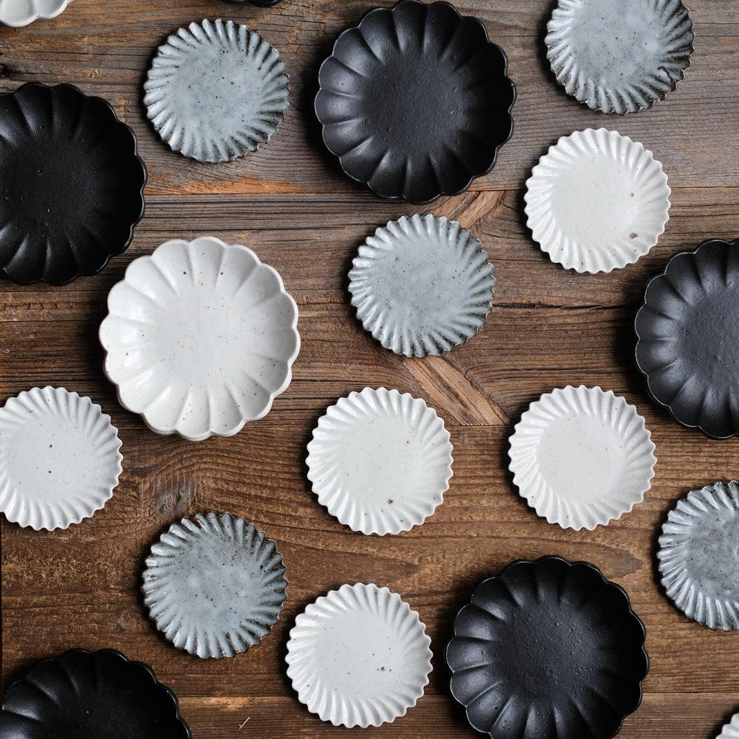 Assiette en grès noire en forme de fleur réalisée par le céramiste Shin Ito
