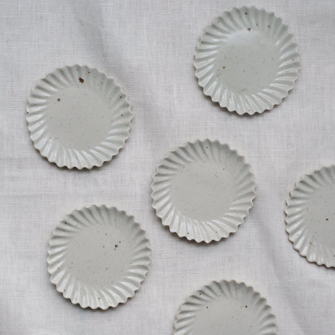Assiette en grès blanche en forme de fleur réalisée par le céramiste Shin Ito