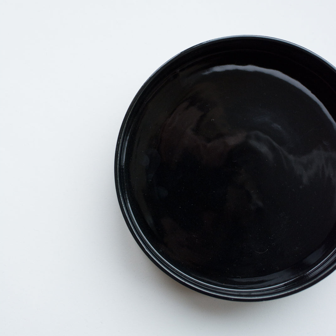 Assiette creuse noire faite à la main dans l'atelier parisien de Pia Van Peteghem, céramiste