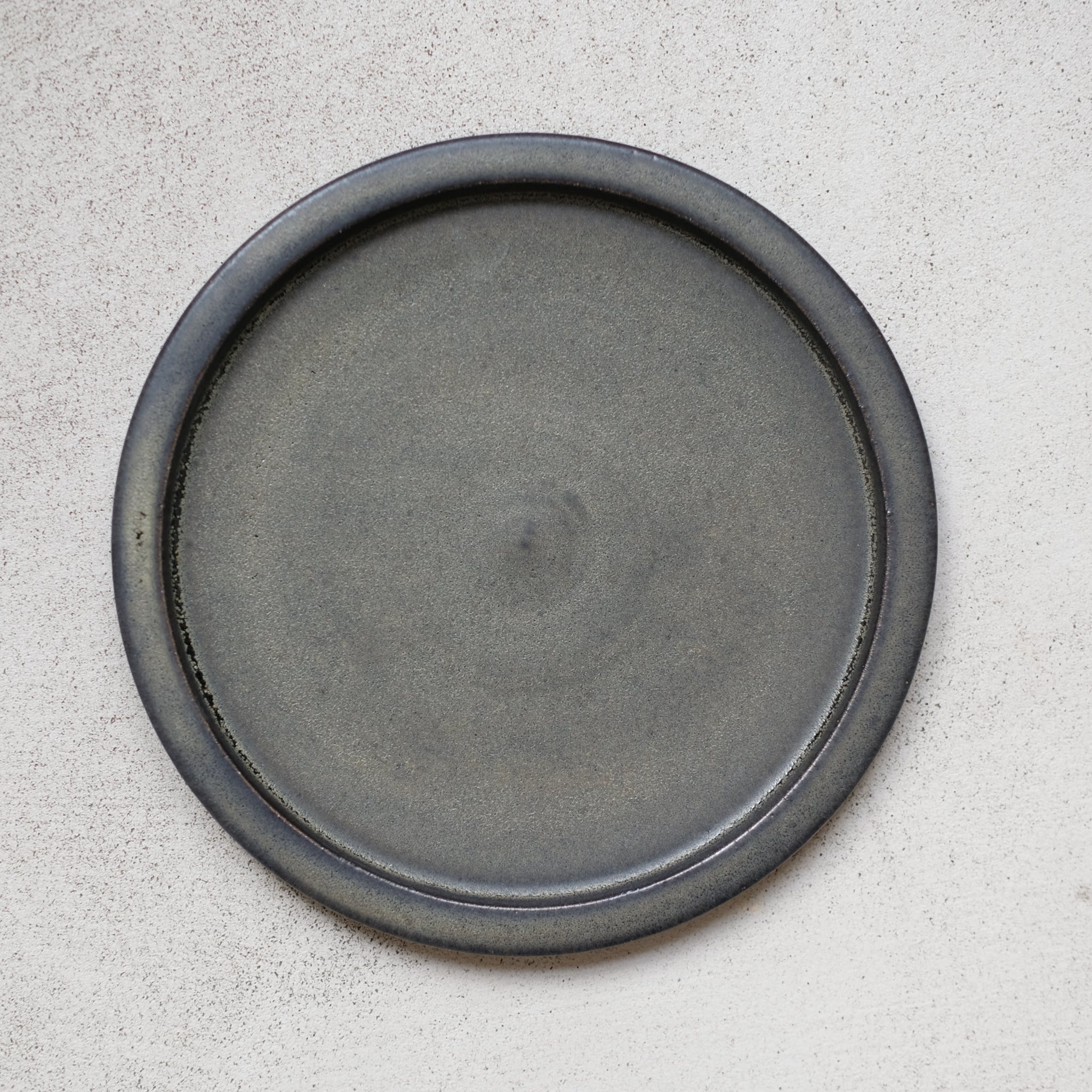 Assiette en grès noir mouchetée par Léa Guetta chez Brutal Ceramics