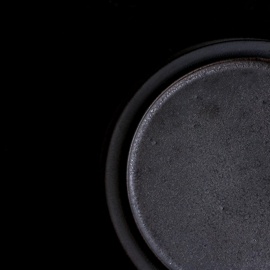 les assiettes noires du potier japonais Atsushi Funakushi