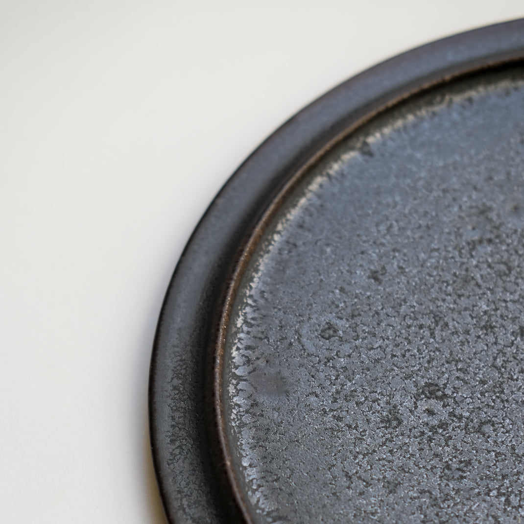 les assiettes noires du potier japonais Atsushi Funakushi