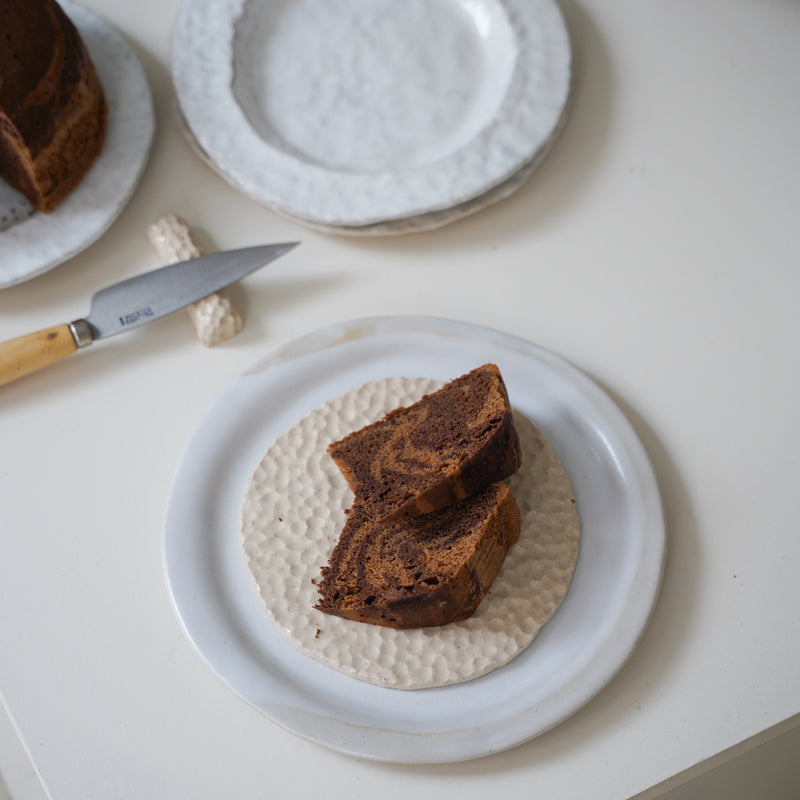 Assiette martelée en grès blanc par Simone Loo chez Brutal Ceramics