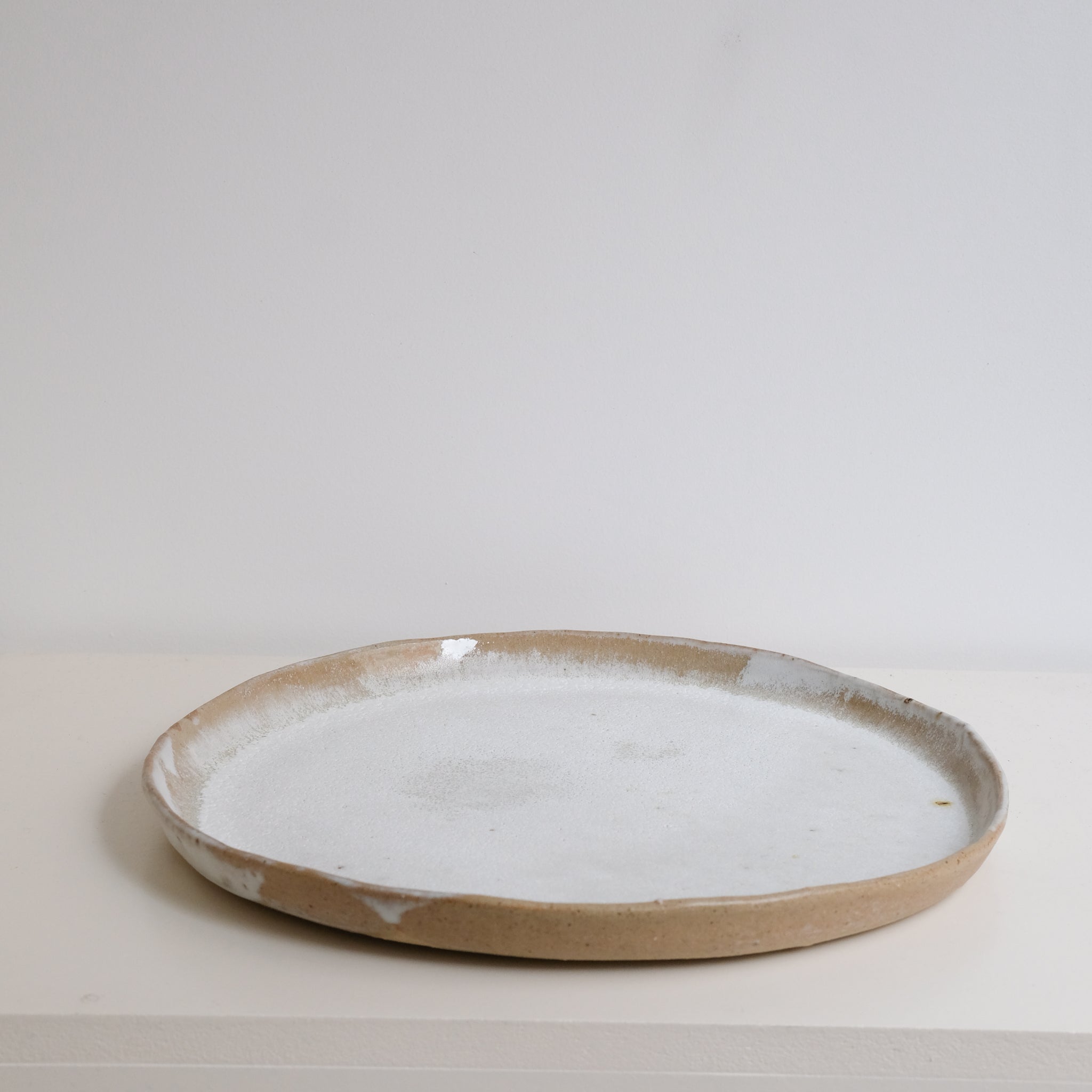 Plateau en grès récolté D 35cm - blanc et bruns de Nathalie Reocreux chez Brutal Ceramics