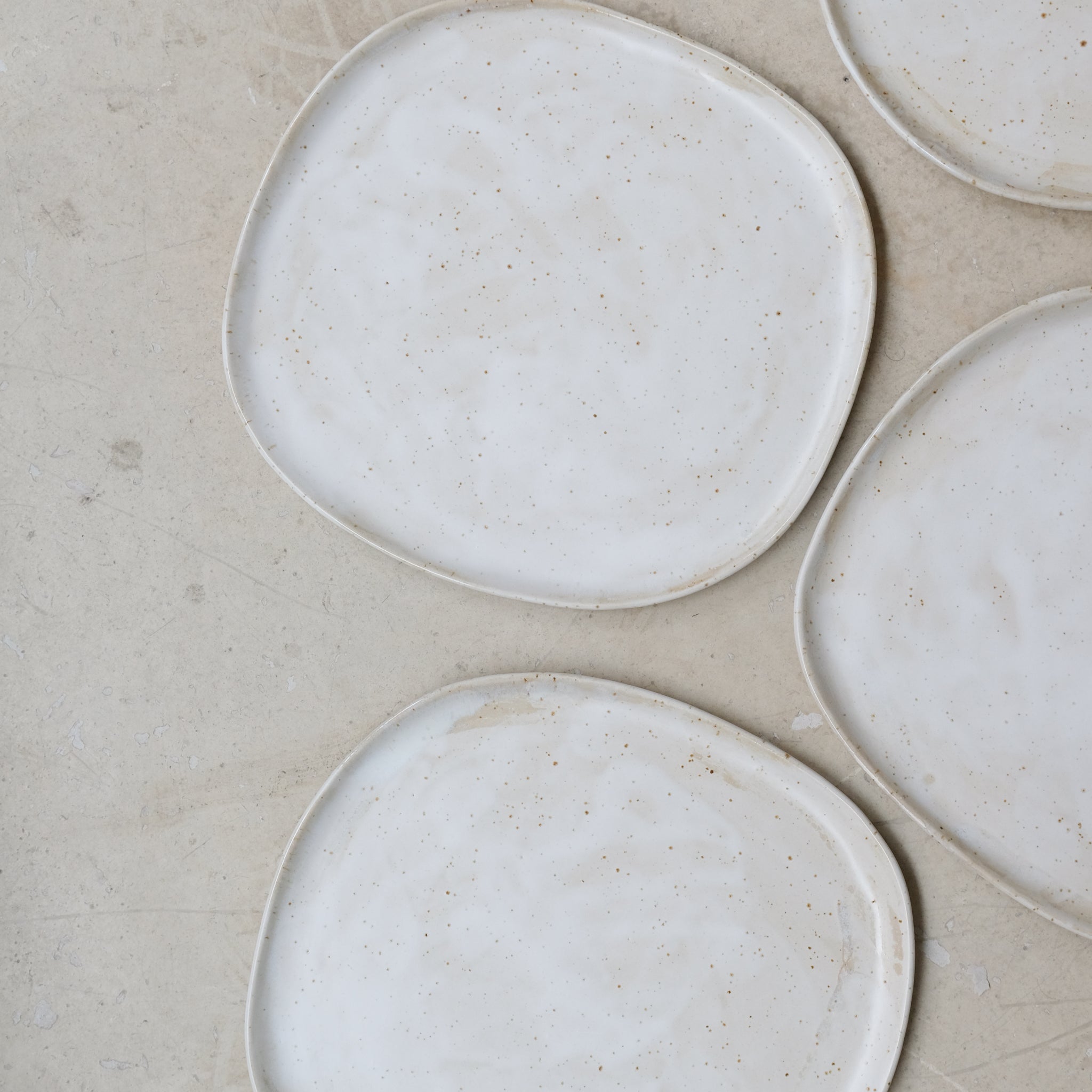 Assiette en grès pyrité D 27cm - blanc moucheté de Sonia Deleani chez Brutal Ceramics