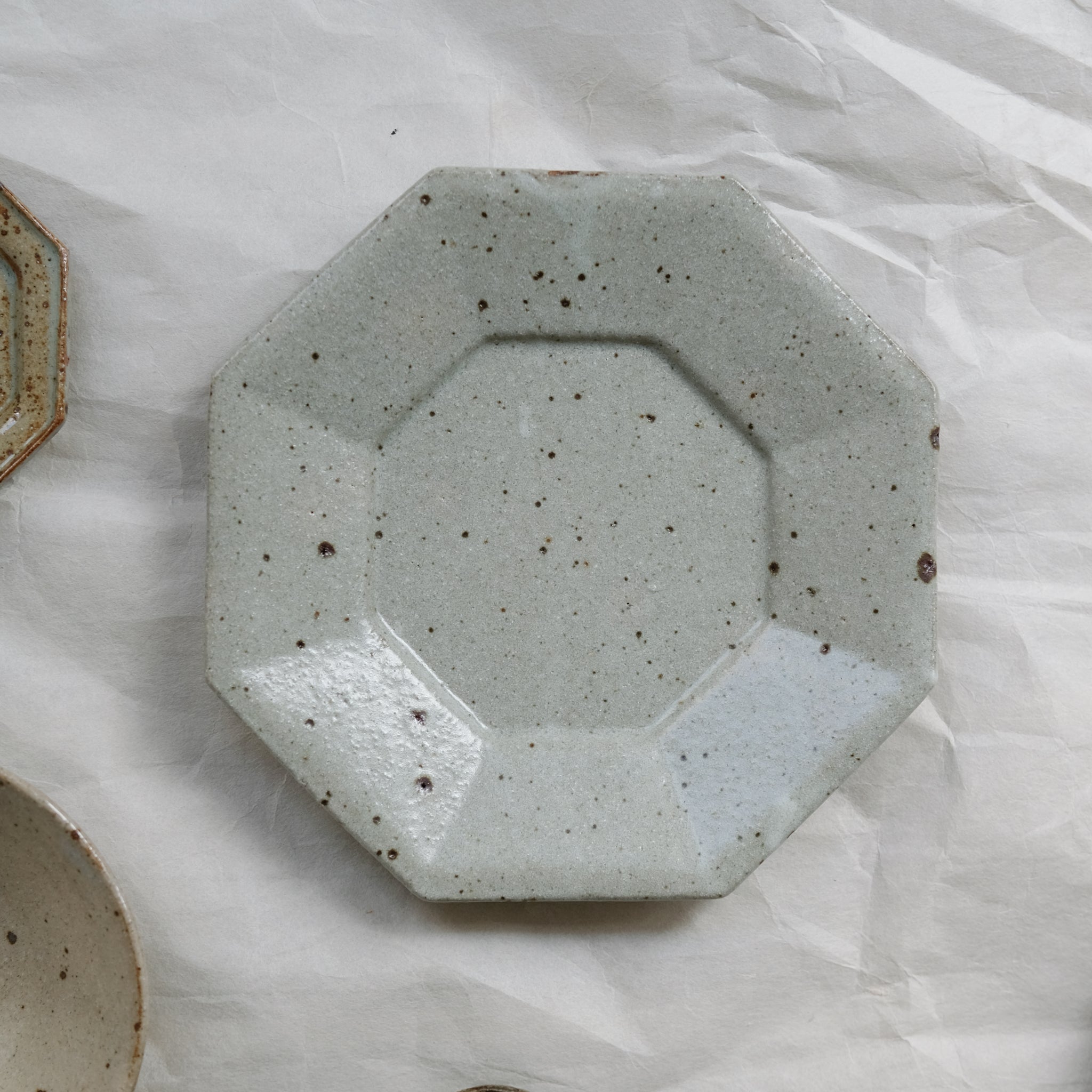 Assiette octogonale en grès D 19cm - blanc gris de Yoh Kashiwai chez Brutal Ceramics