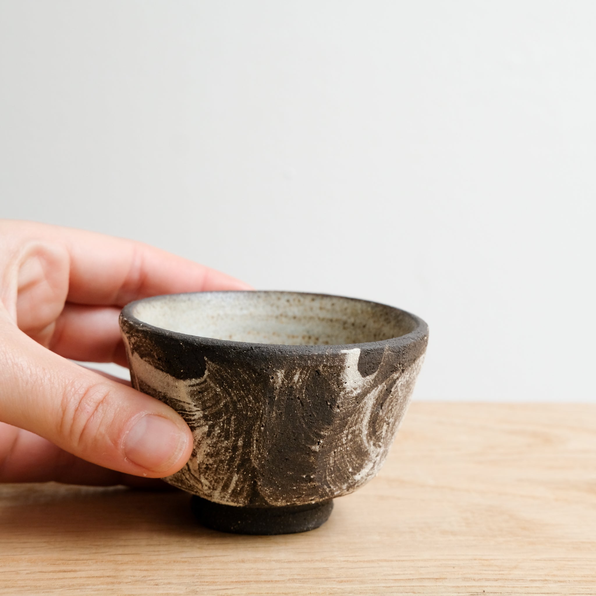 Tasse en grès noir 70 ml - noir brut et blanc de Maya Carves chez Brutal Ceramics